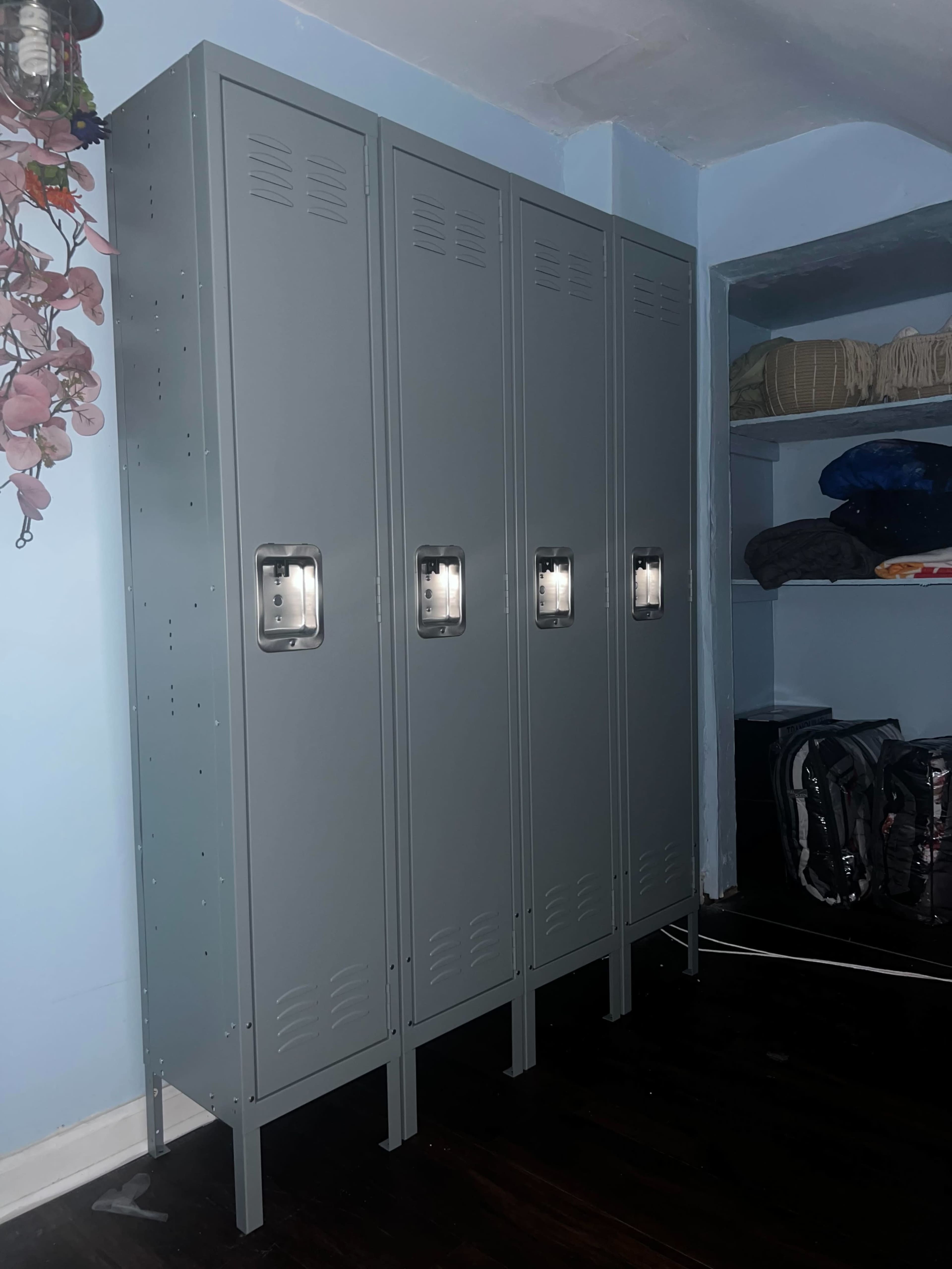 Four gray metal lockers arranged neatly against a wall in a room.