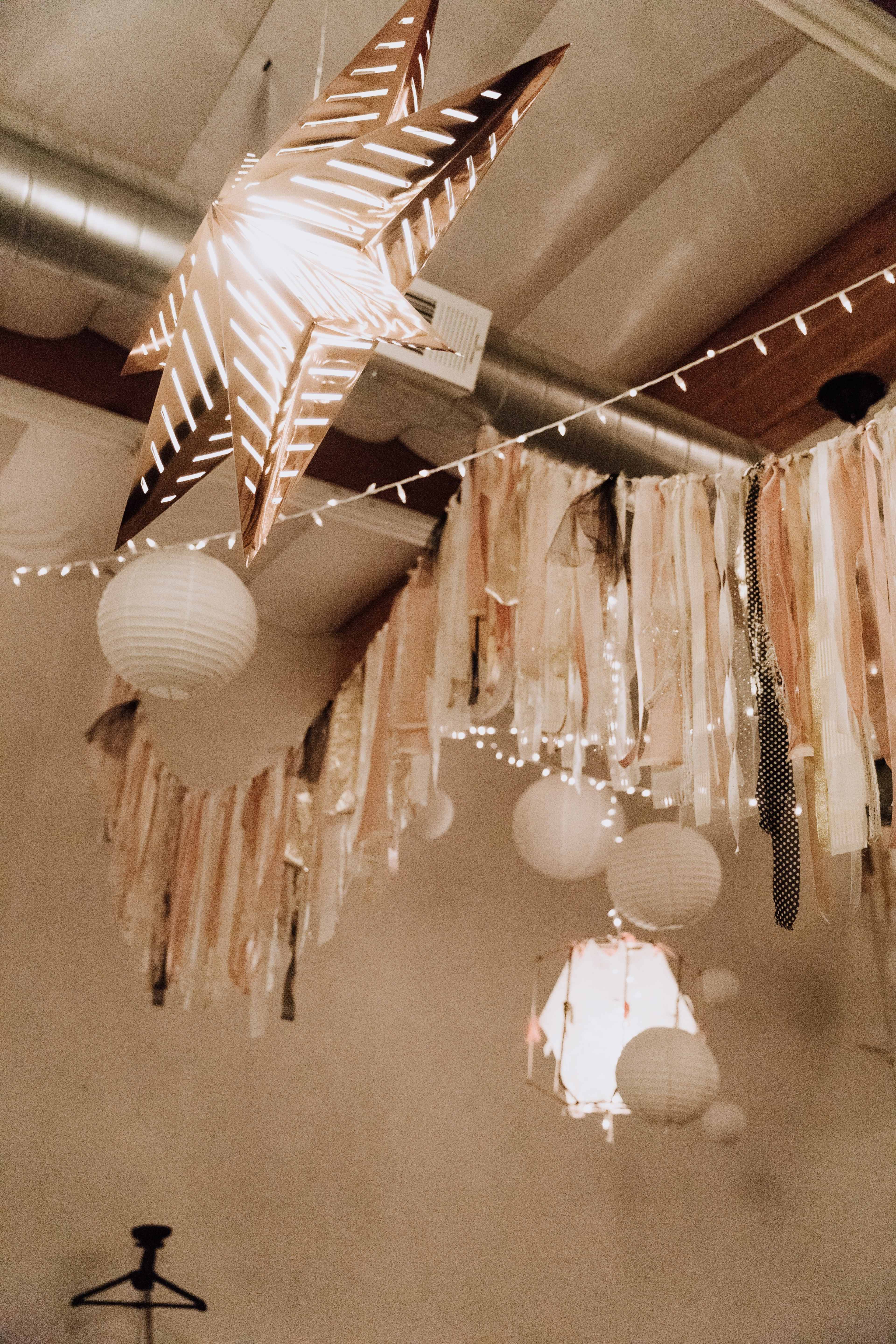 The ceiling is adorned with paper lanterns, decorative strips of fabric, and star-shaped light fixtures.