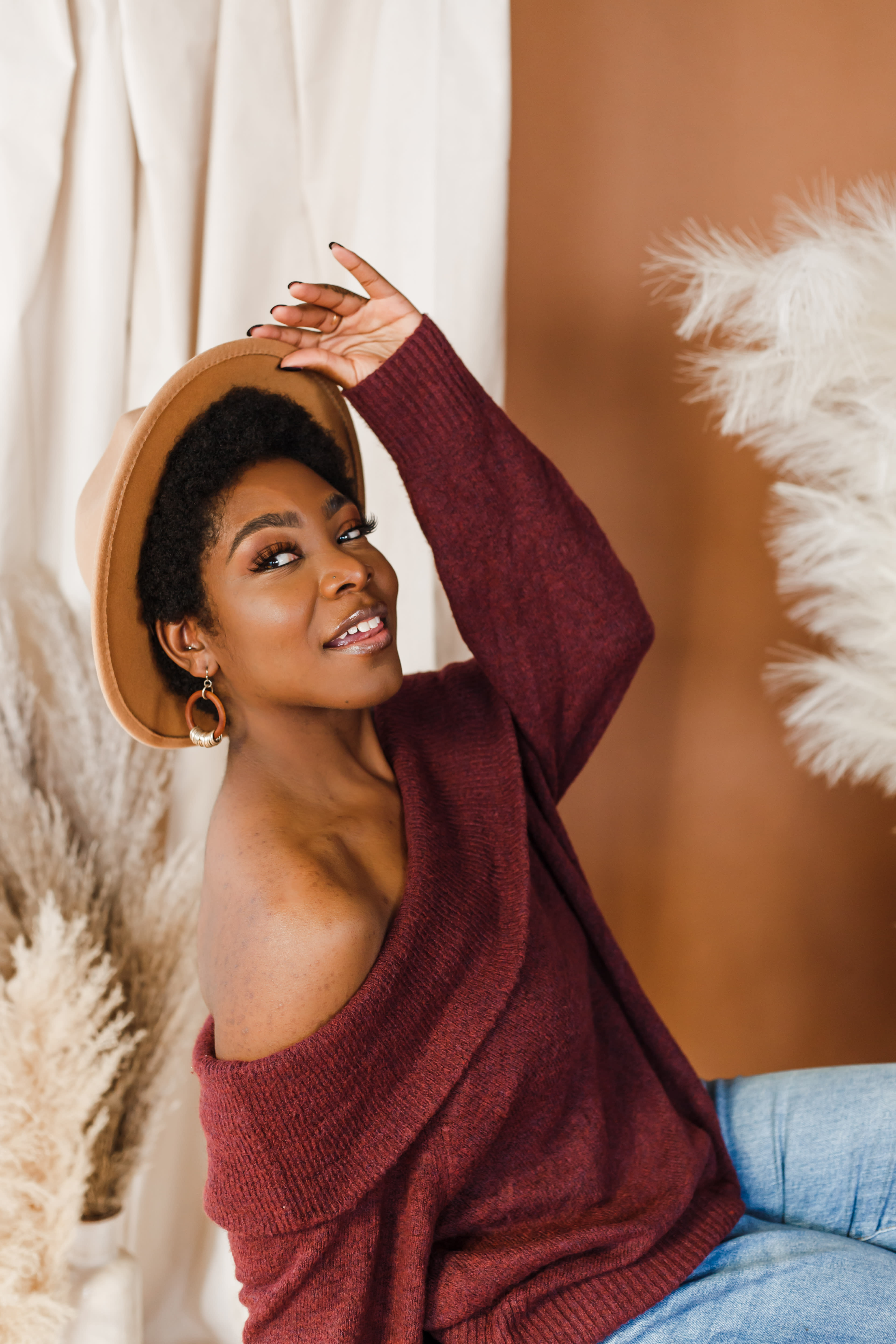 Une femme portant un chapeau de couleur beige posant pendant un shooting photo.