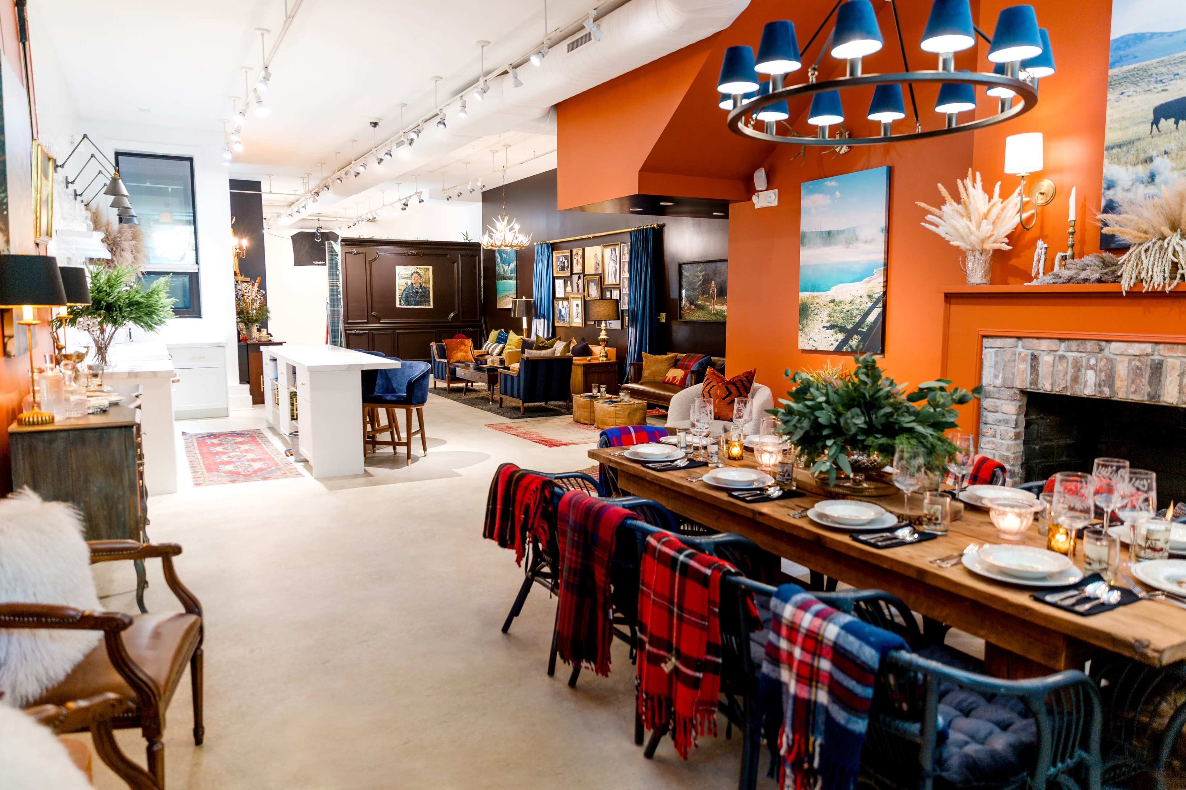 The image shows a stylishly decorated interior space featuring an open layout with a dining area, a living area with comfortable seating, and a cozy fireplace.