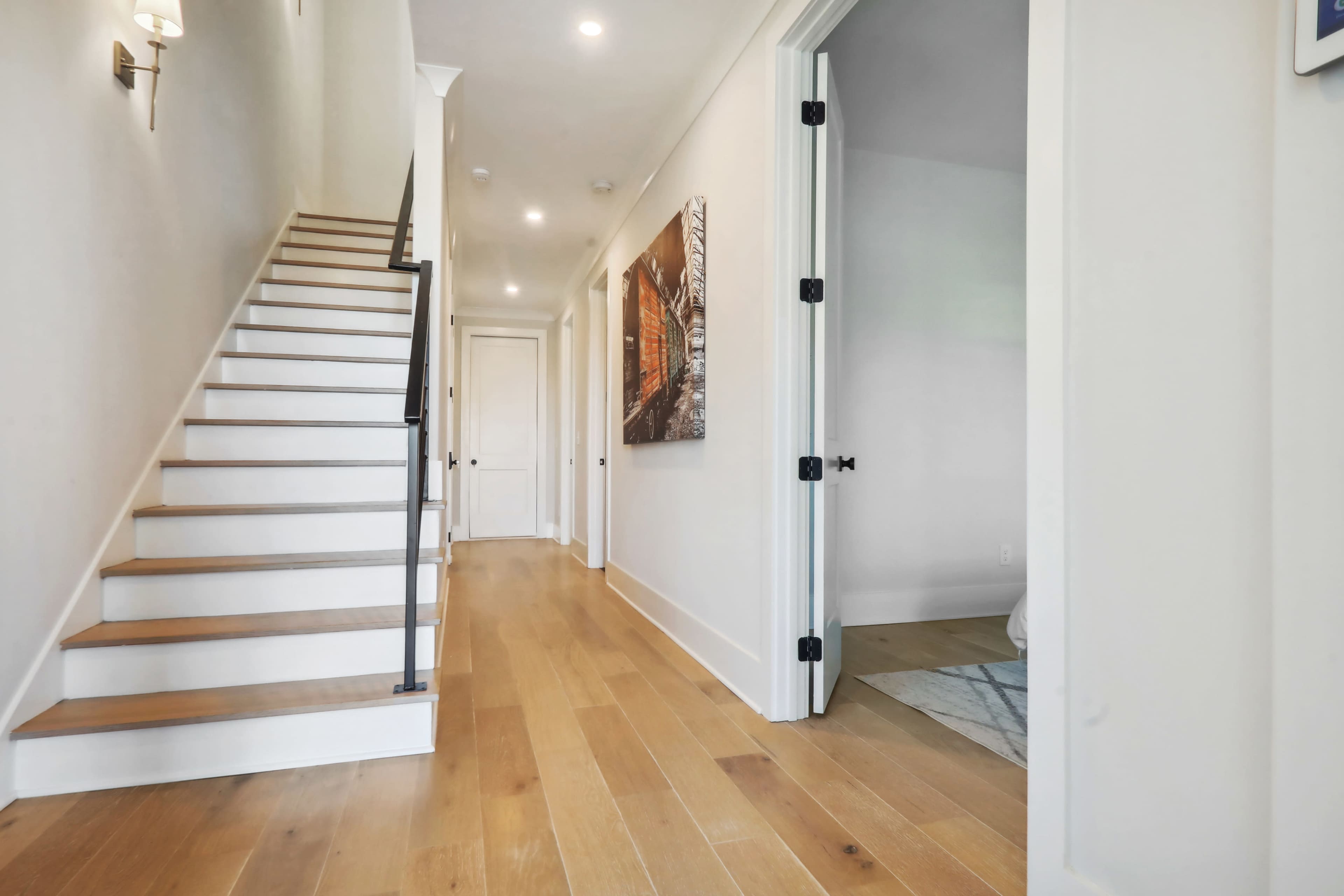 A neatly designed hallway with a staircase and a doorway leading to another room.