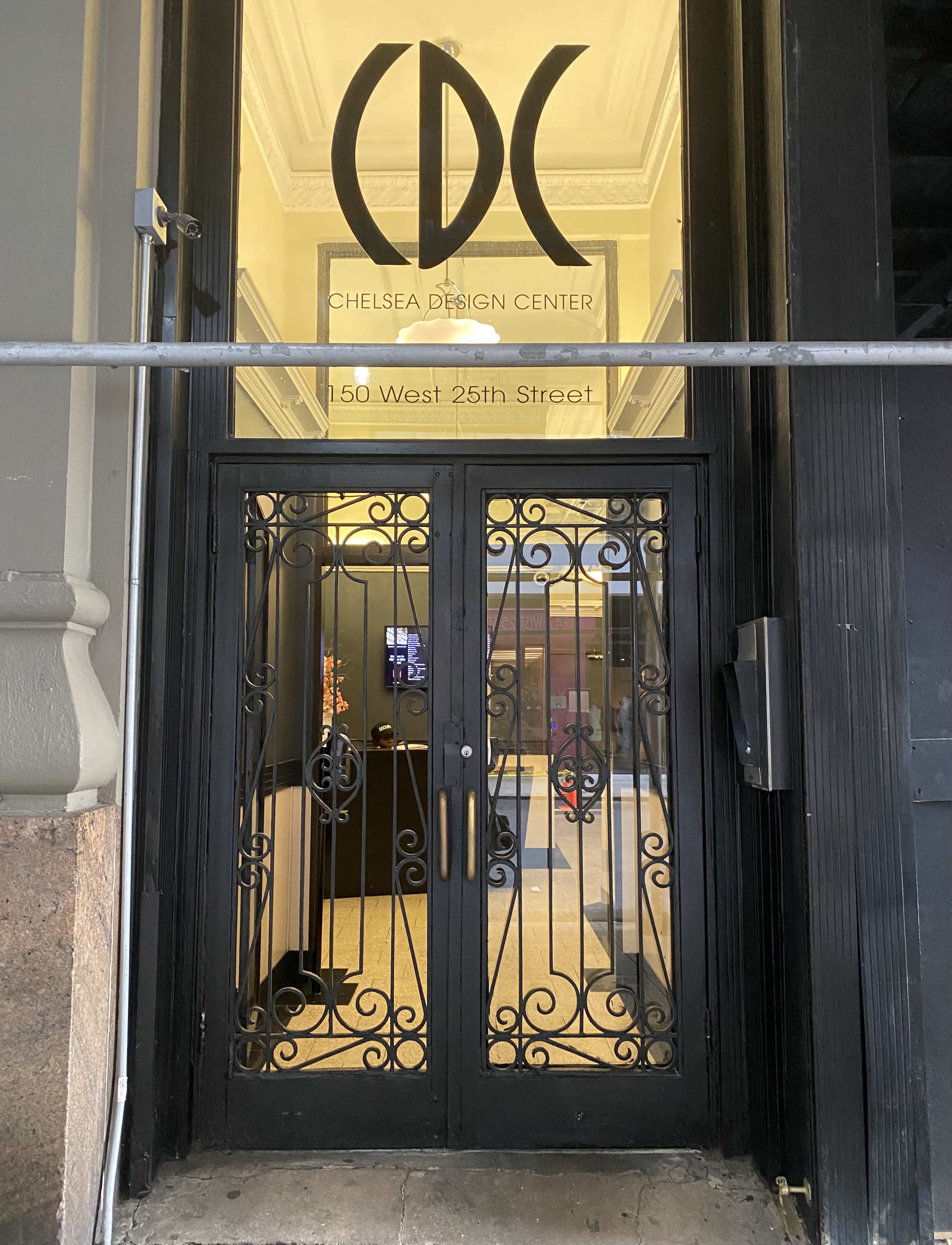 A decorative entrance door of the Chelsea Design Center, with the logo displayed above and the address on a sign.