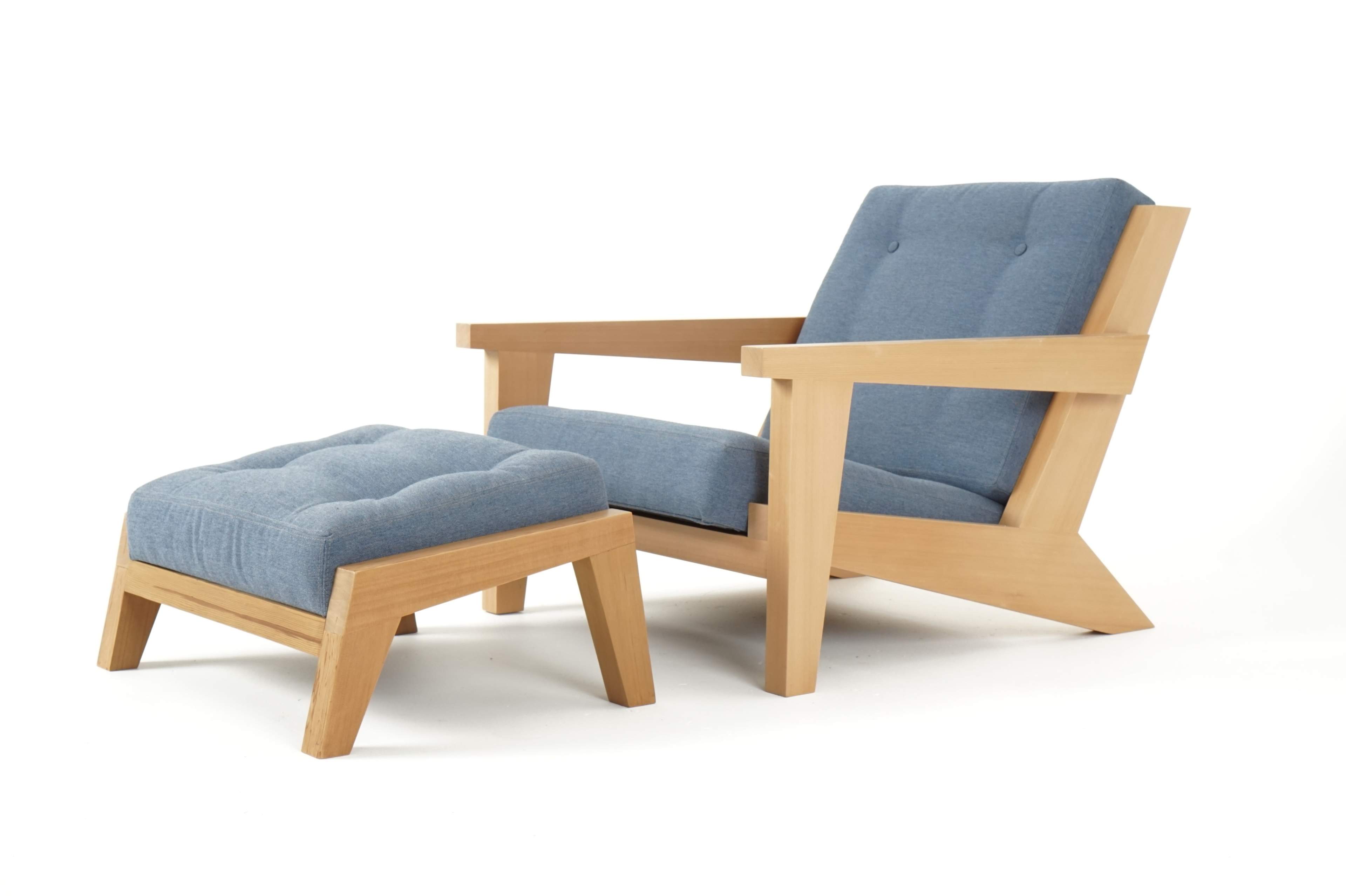 The image features a wooden armchair with a blue upholstered seat and matching ottoman.