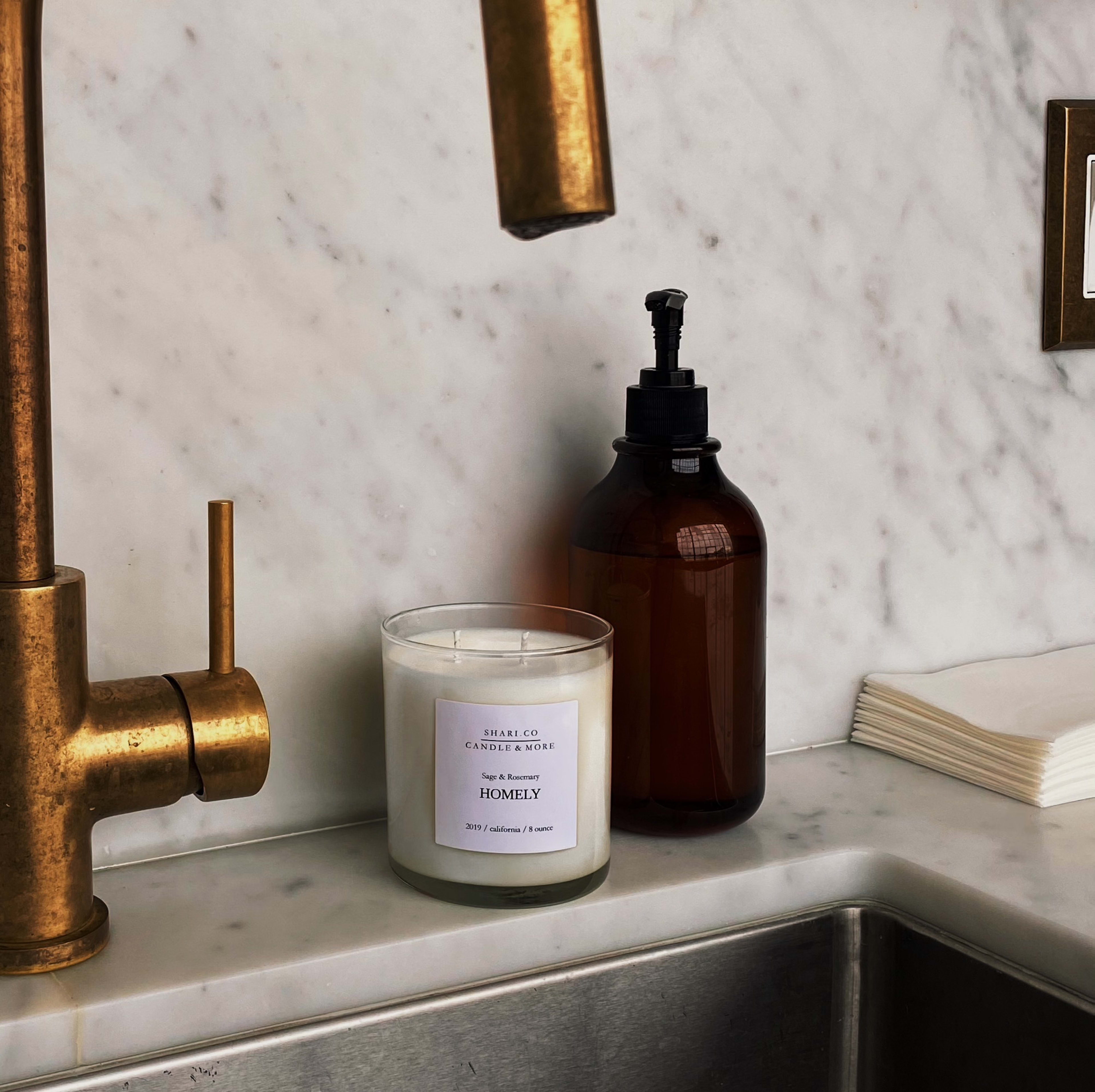 A product photoshoot featuring a candle on a counter by a sink.