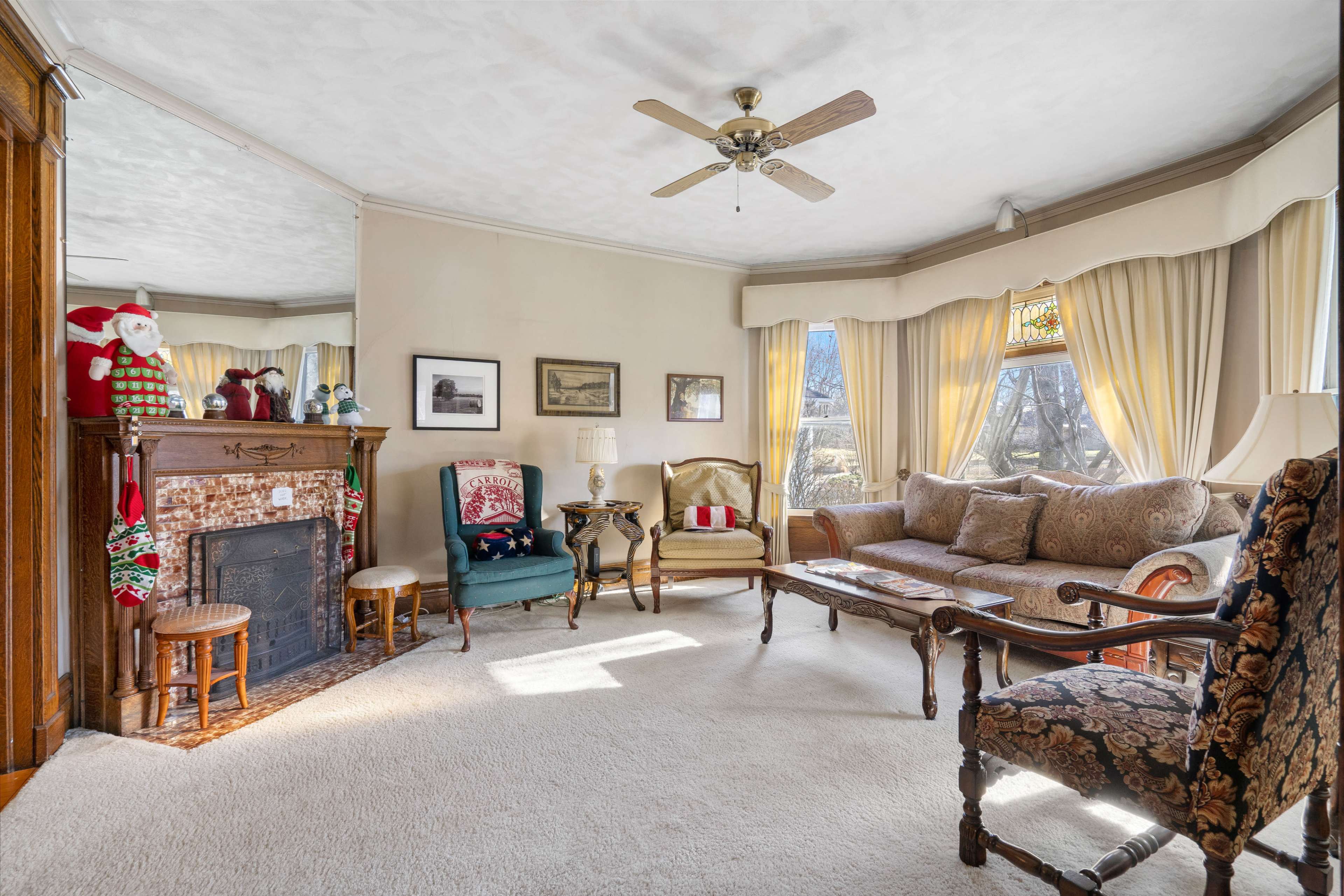 The living room features a fireplace surrounded by seating, with large windows allowing natural light to illuminate the space.