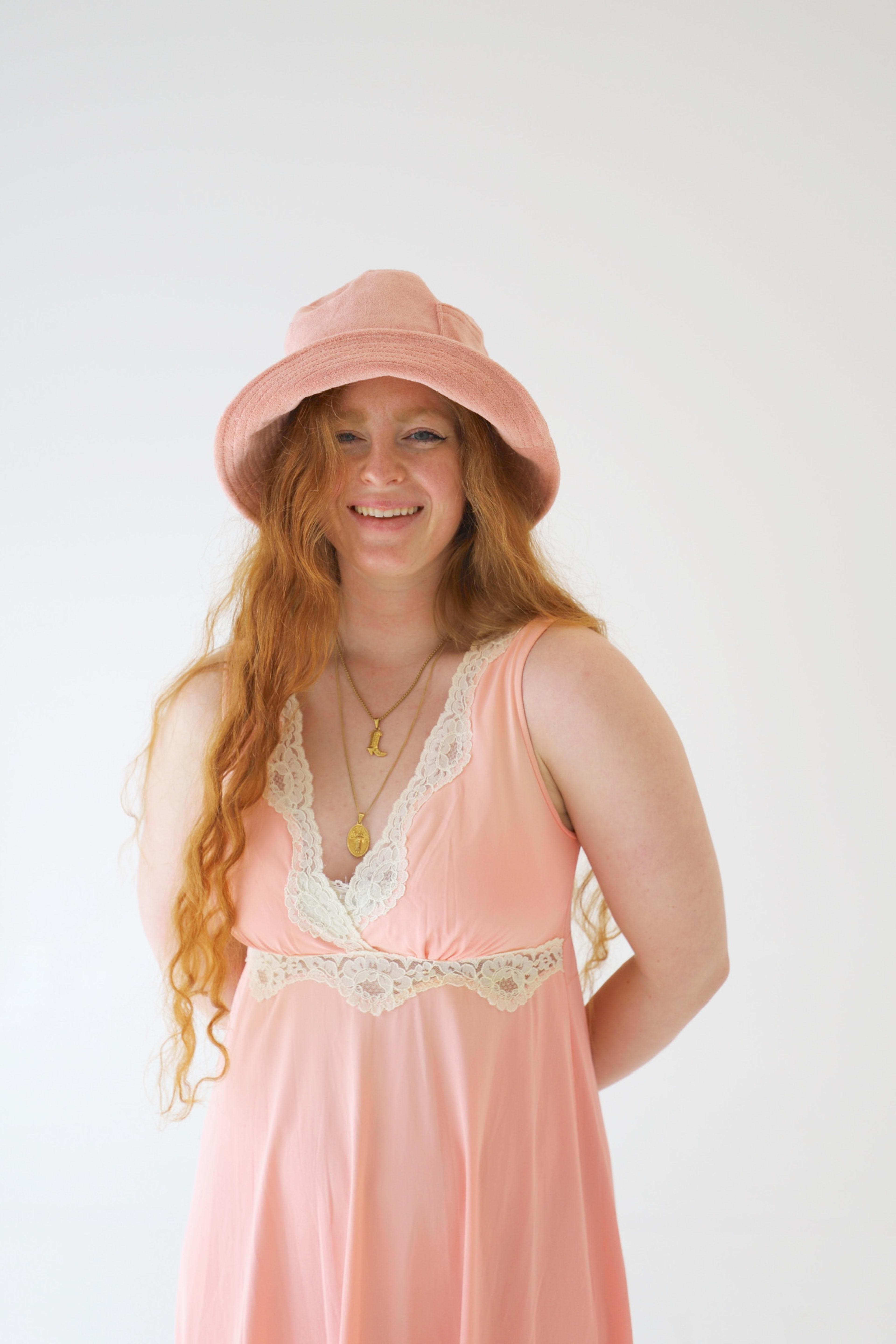 A fashion photo shoot featuring a woman in a pink dress and hat.