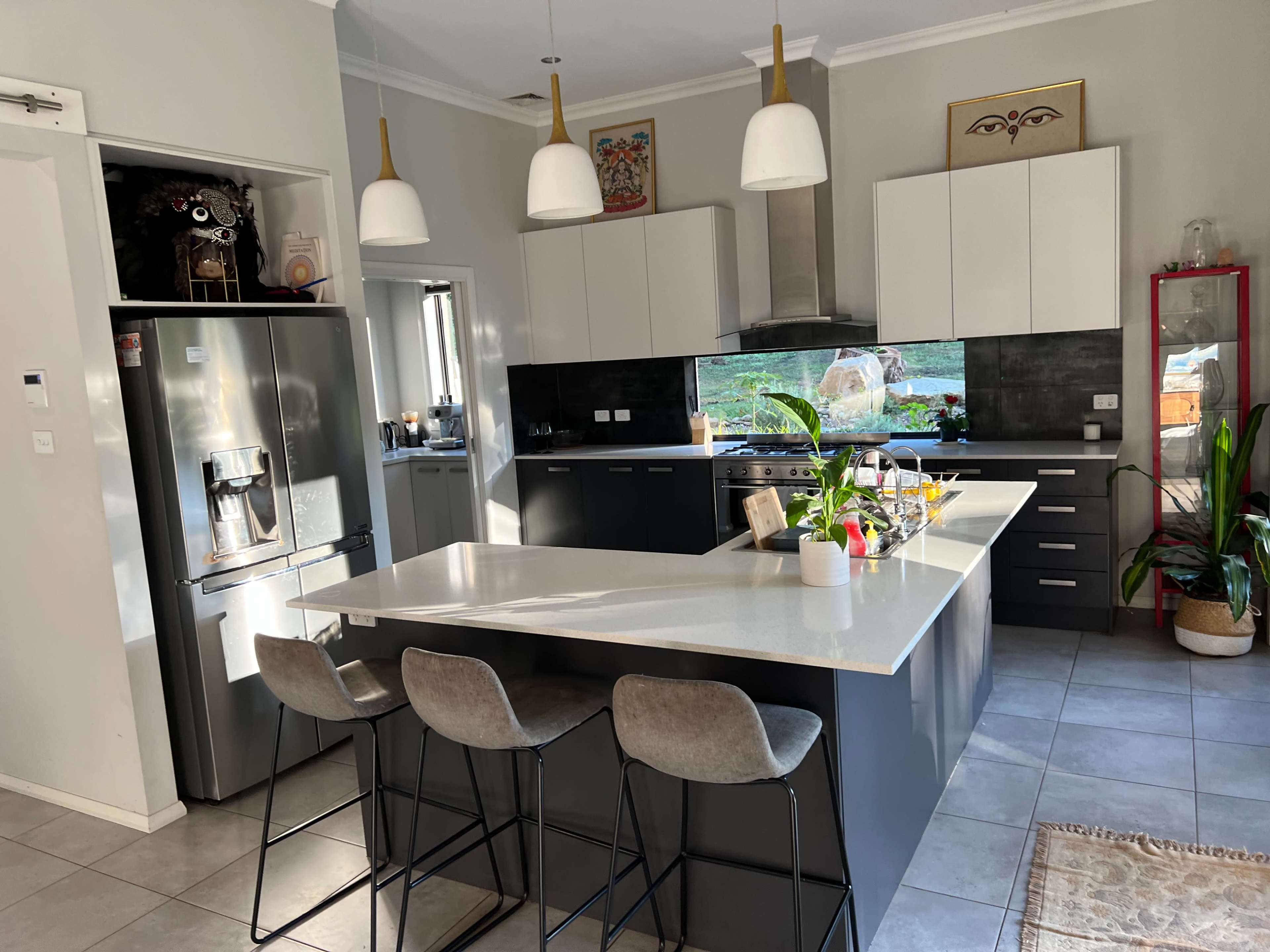 The kitchen features a large island with seating, modern appliances, and natural light illuminating the space.