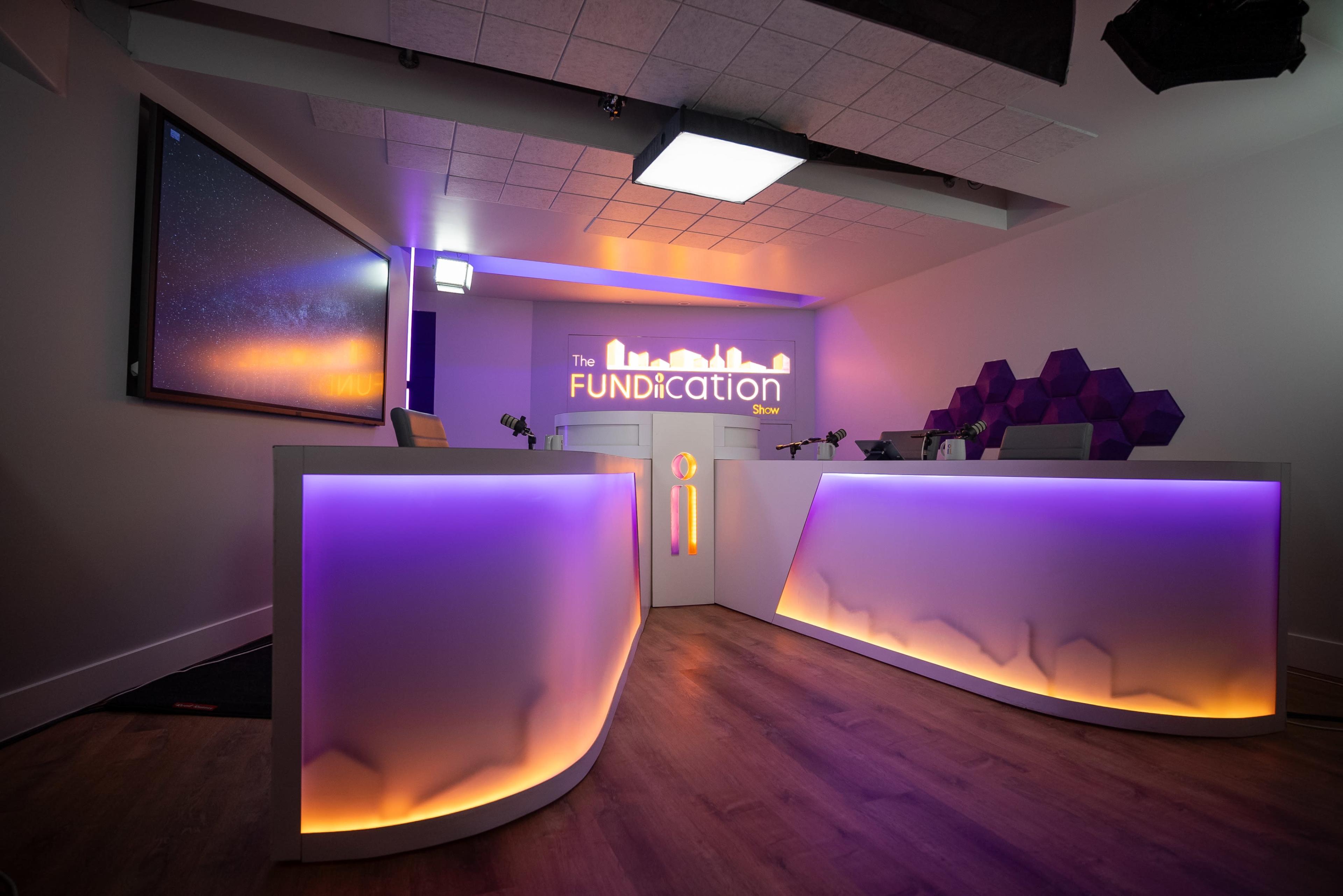 A modern reception area with a sleek, illuminated desk and a large screen displaying a starry background.