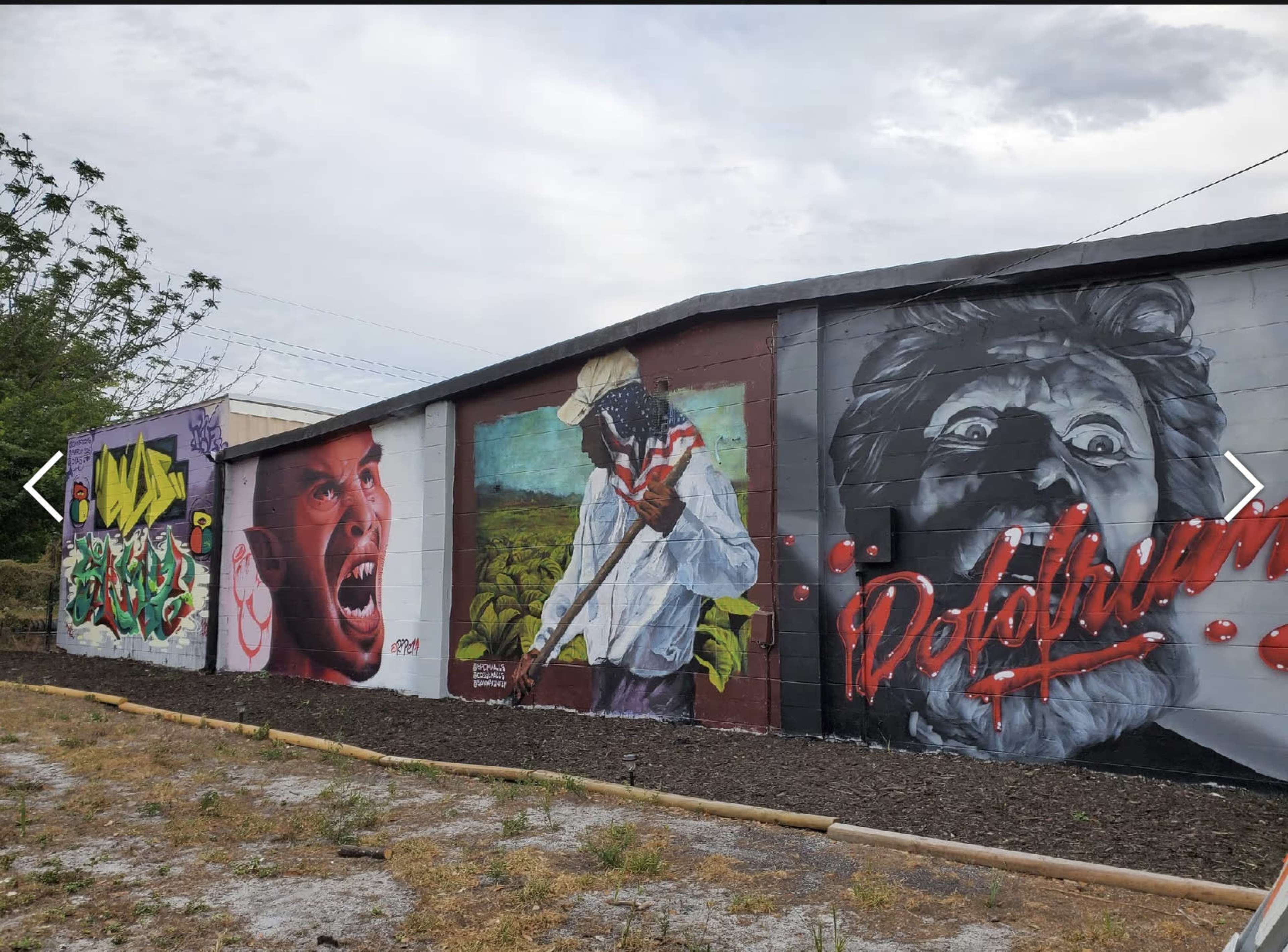 A mural on a wall featuring several large, colorful portraits, including a shouting individual, a person holding a cane in a field, and a character with wild hair.