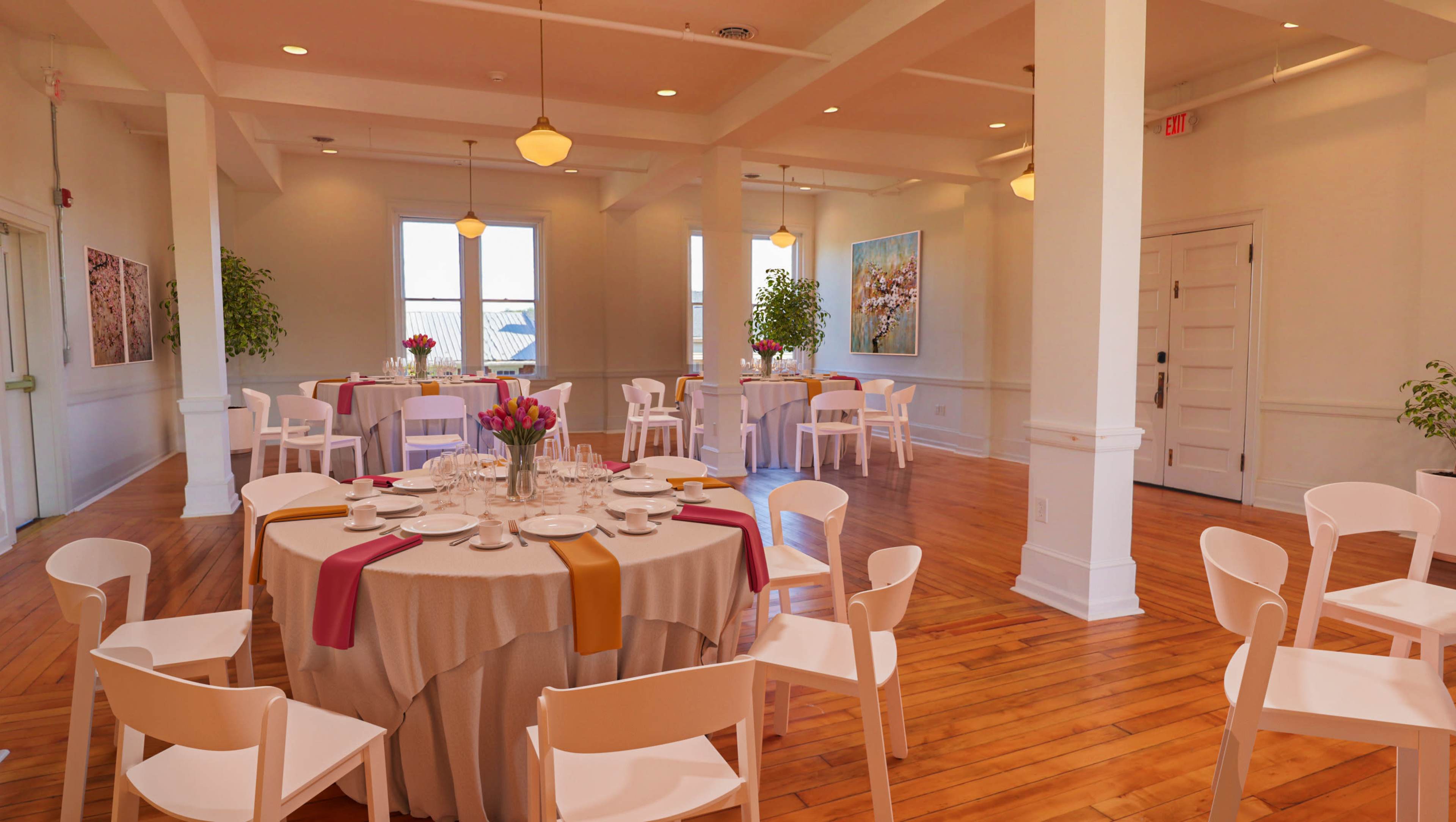 A well-lit dining area features round tables set with tableware and surrounded by white chairs.