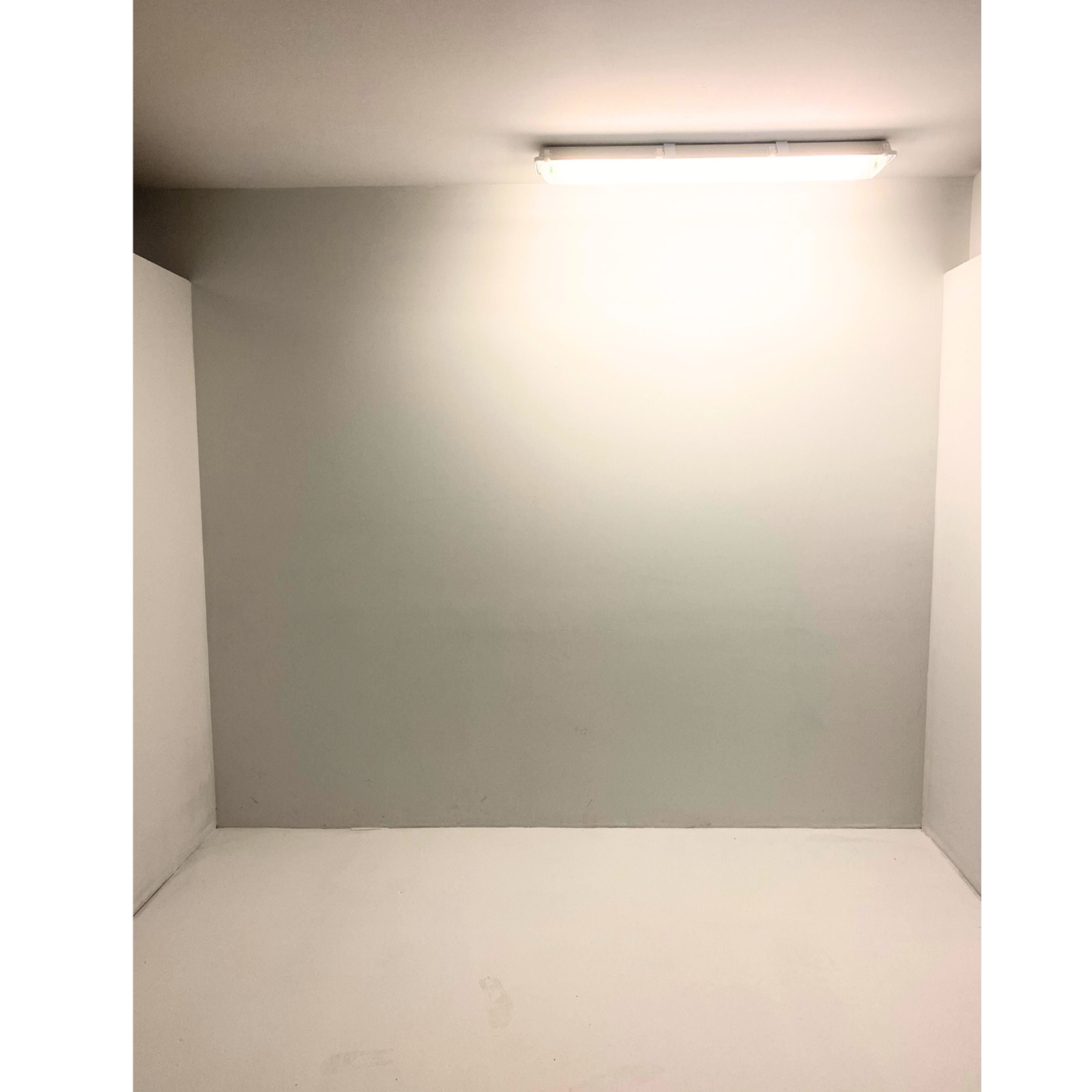 The image shows a plain, empty room with white walls and a ceiling light fixture.