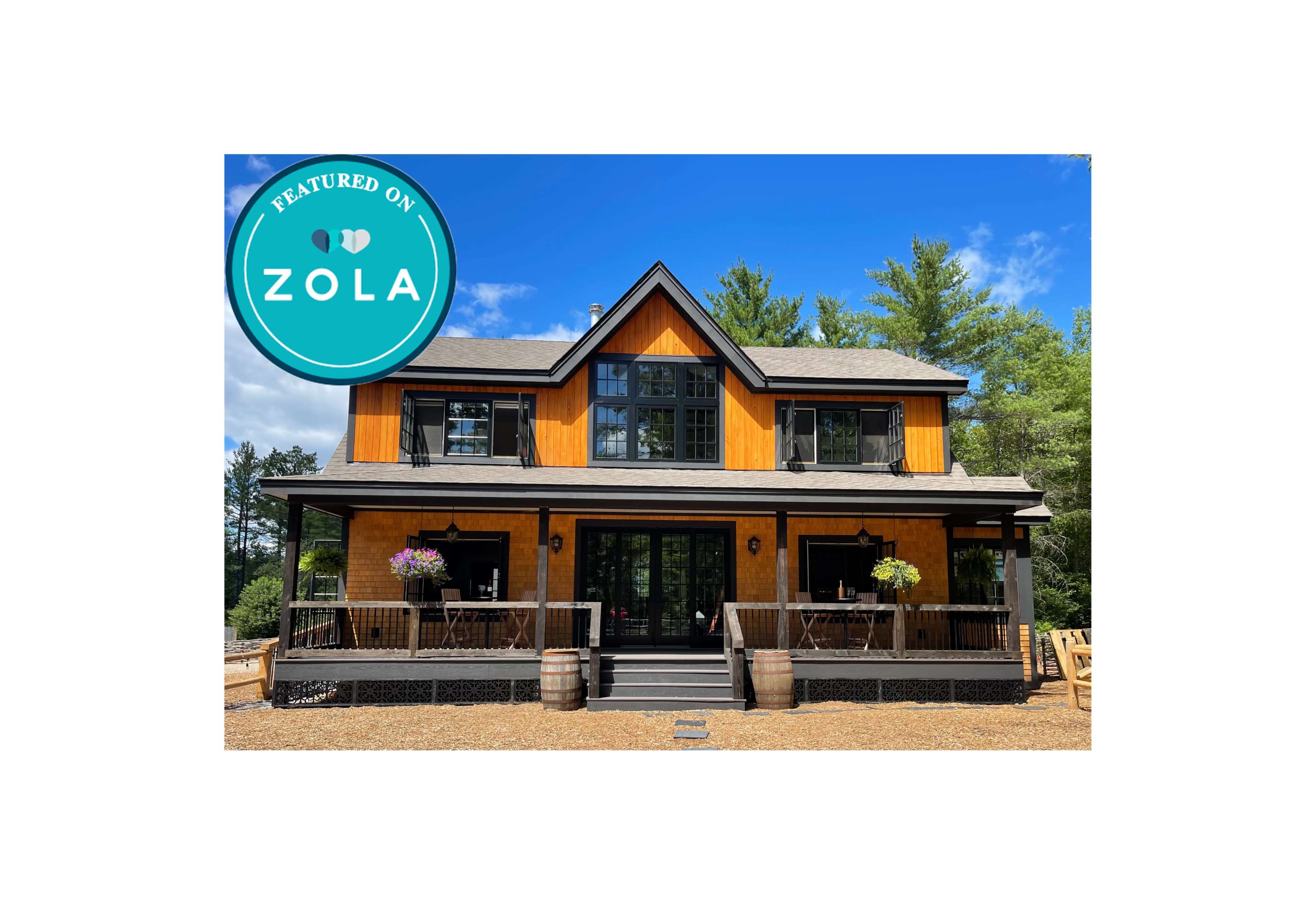 A two-story orange and black house with a front porch, surrounded by trees and featuring flower pots on the railings.
