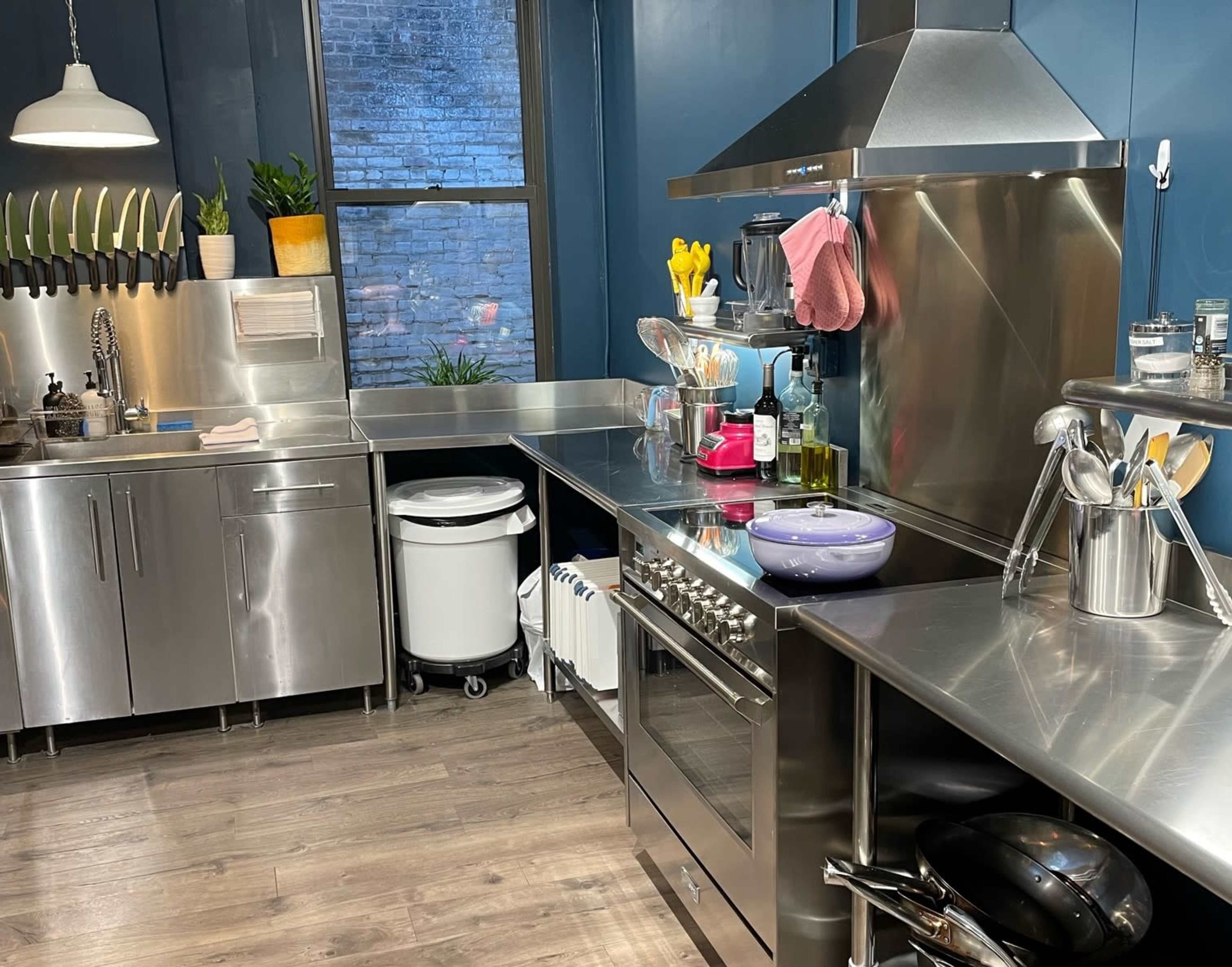A modern kitchen featuring stainless steel appliances, a large window, and a variety of cooking utensils on a countertop.