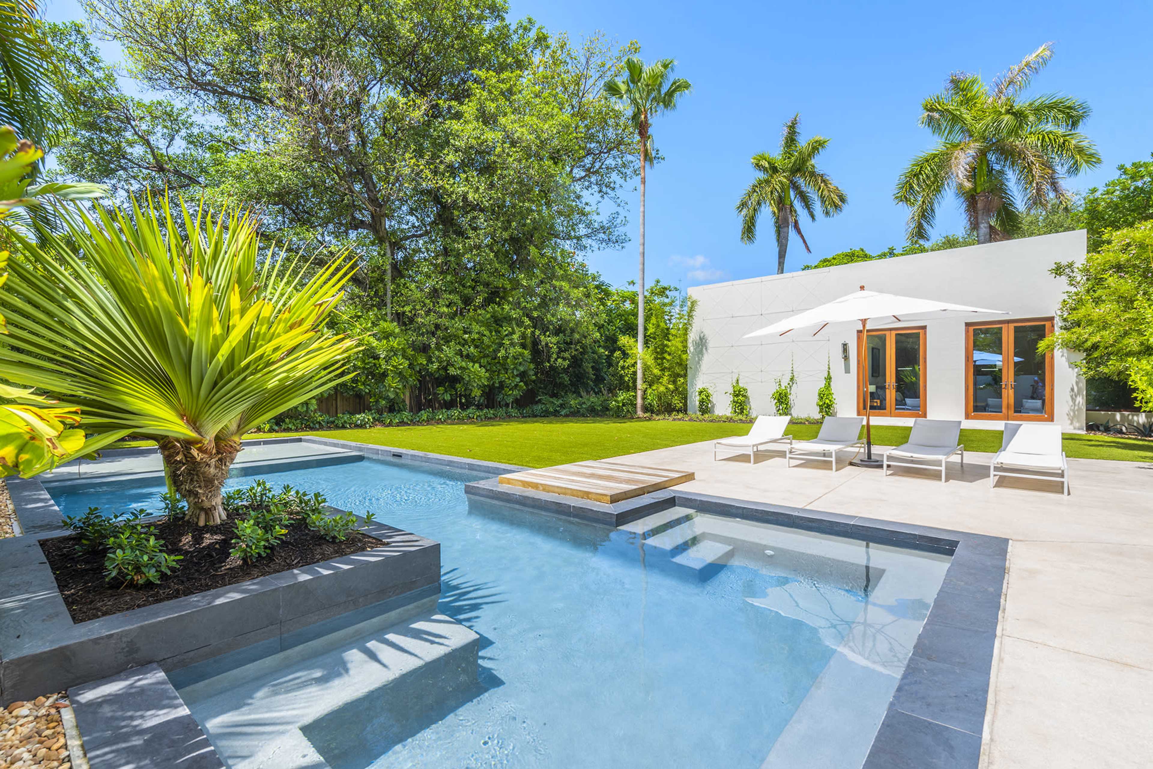 The image features a modern backyard with a swimming pool, lounge chairs, and tropical landscaping.