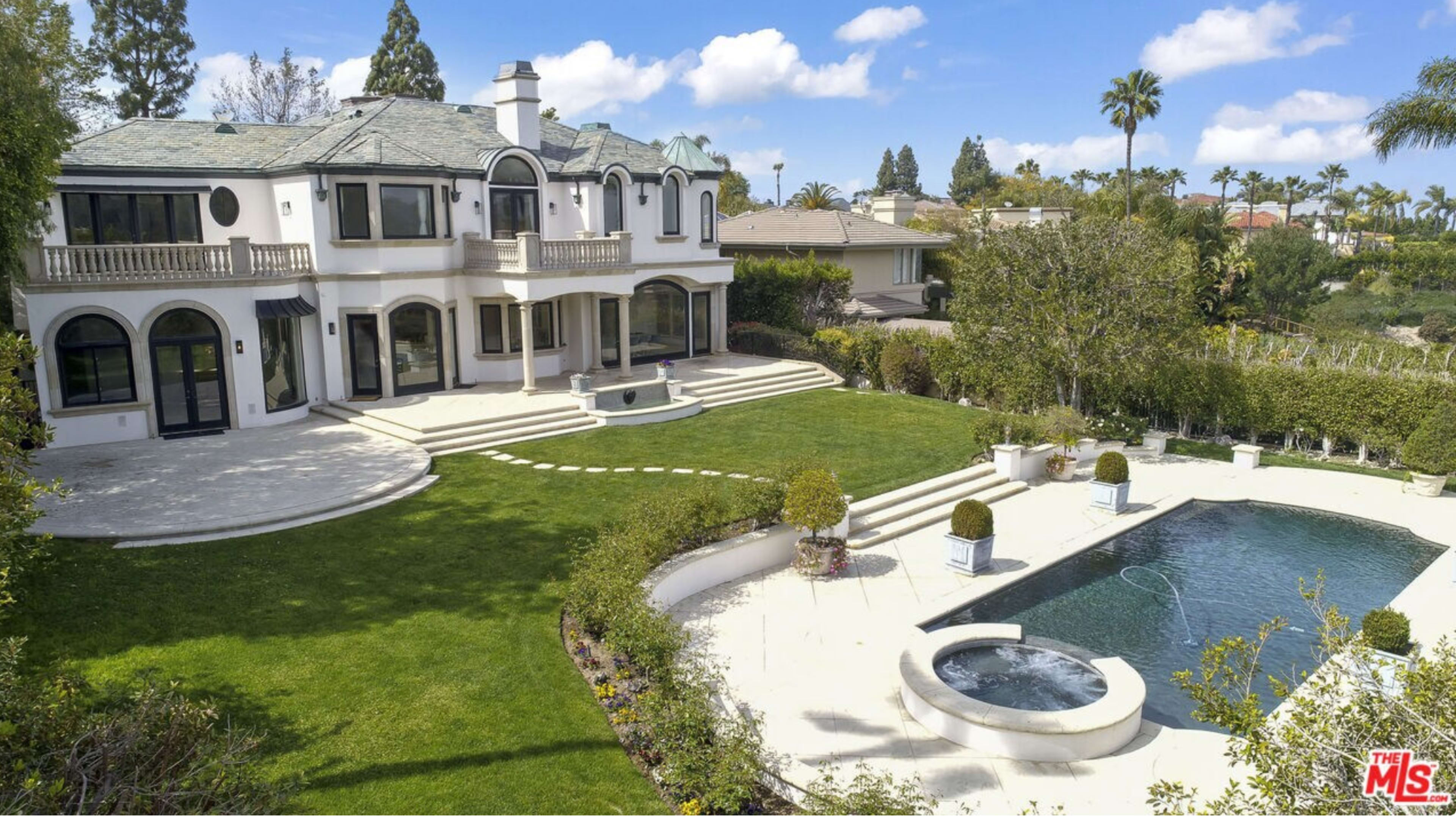 The image shows a two-story house with a landscaped yard, a swimming pool, and a series of steps leading to the back entrance.