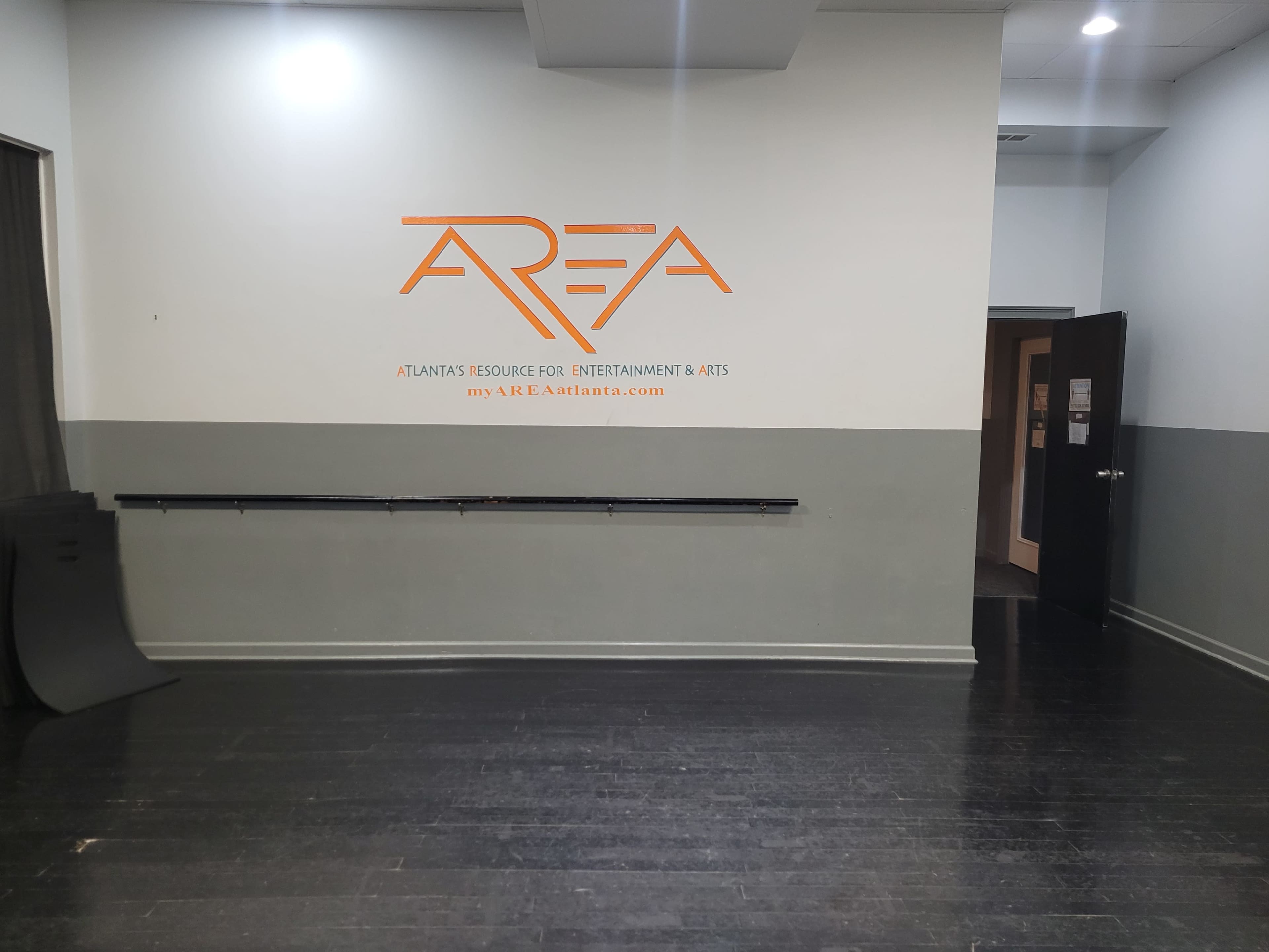 The interior of a room with a gray and white color scheme, featuring a wall with the text "AREA" and the website "myA.R.E.A.atlanta.com" prominently displayed.