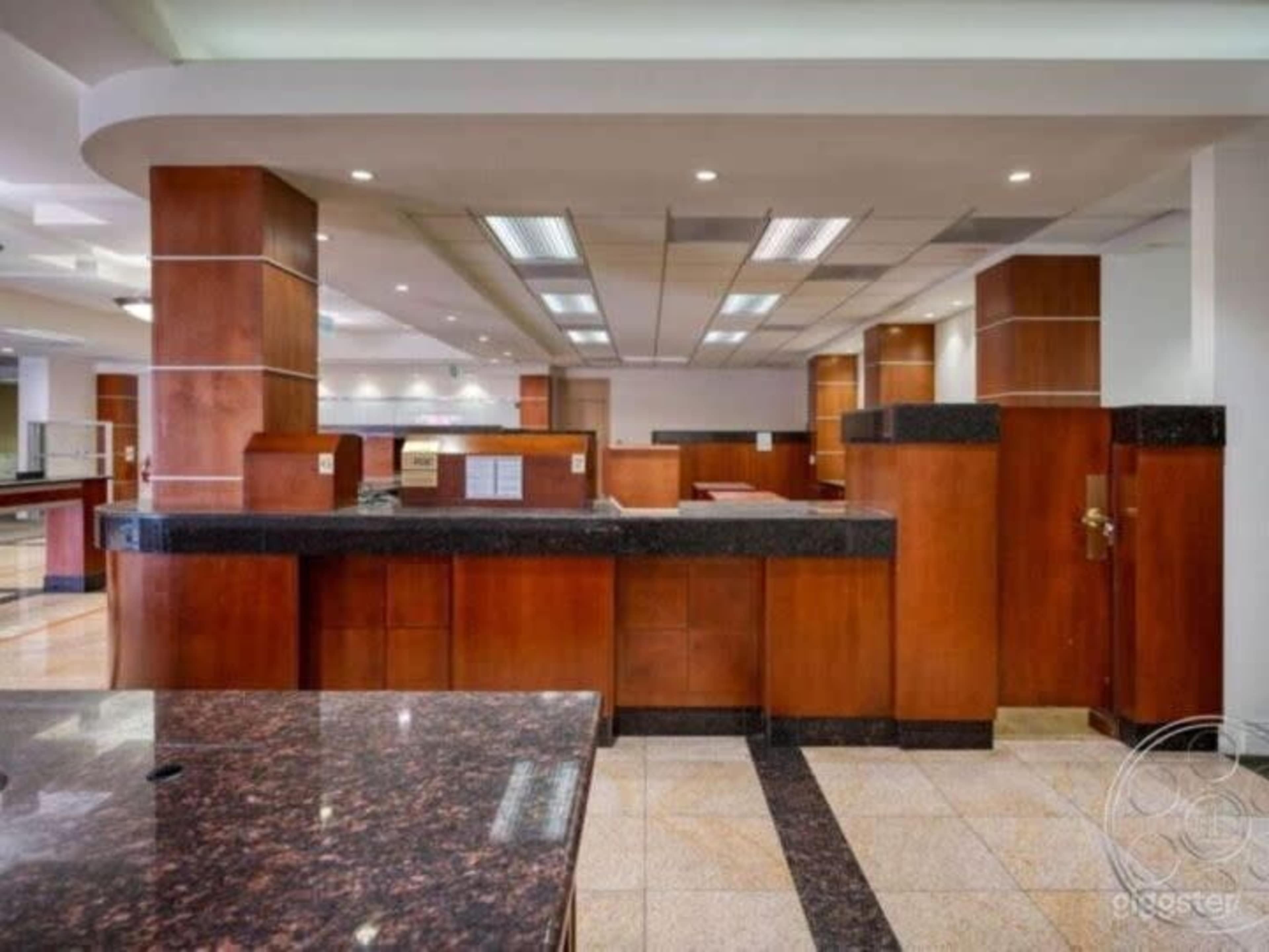 The image shows a spacious, modern kitchen area with wooden cabinetry, granite countertops, and bright overhead lighting.