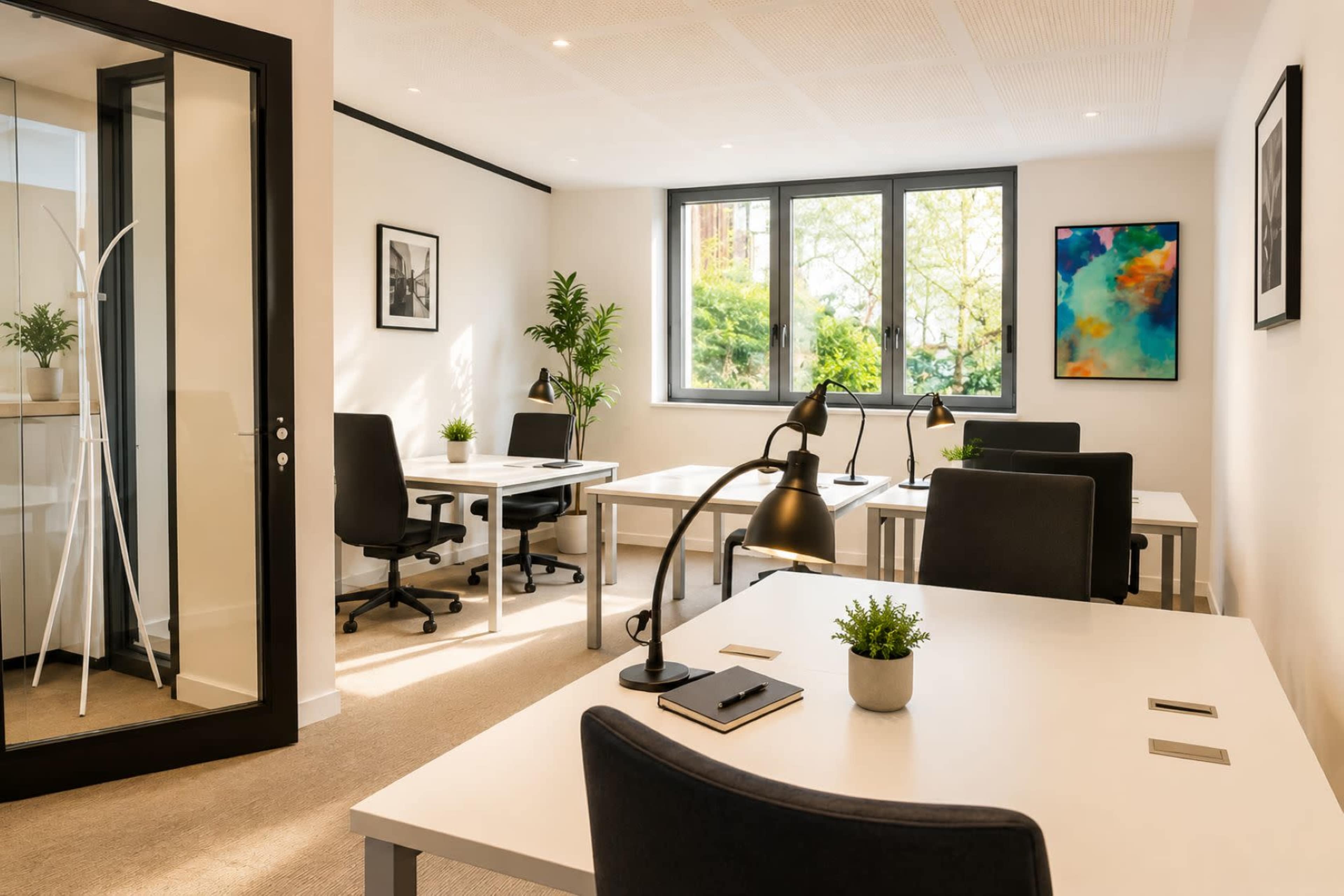 The image depicts a modern office space featuring multiple workstations with white desks, black chairs, and large windows allowing natural light to fill the room.