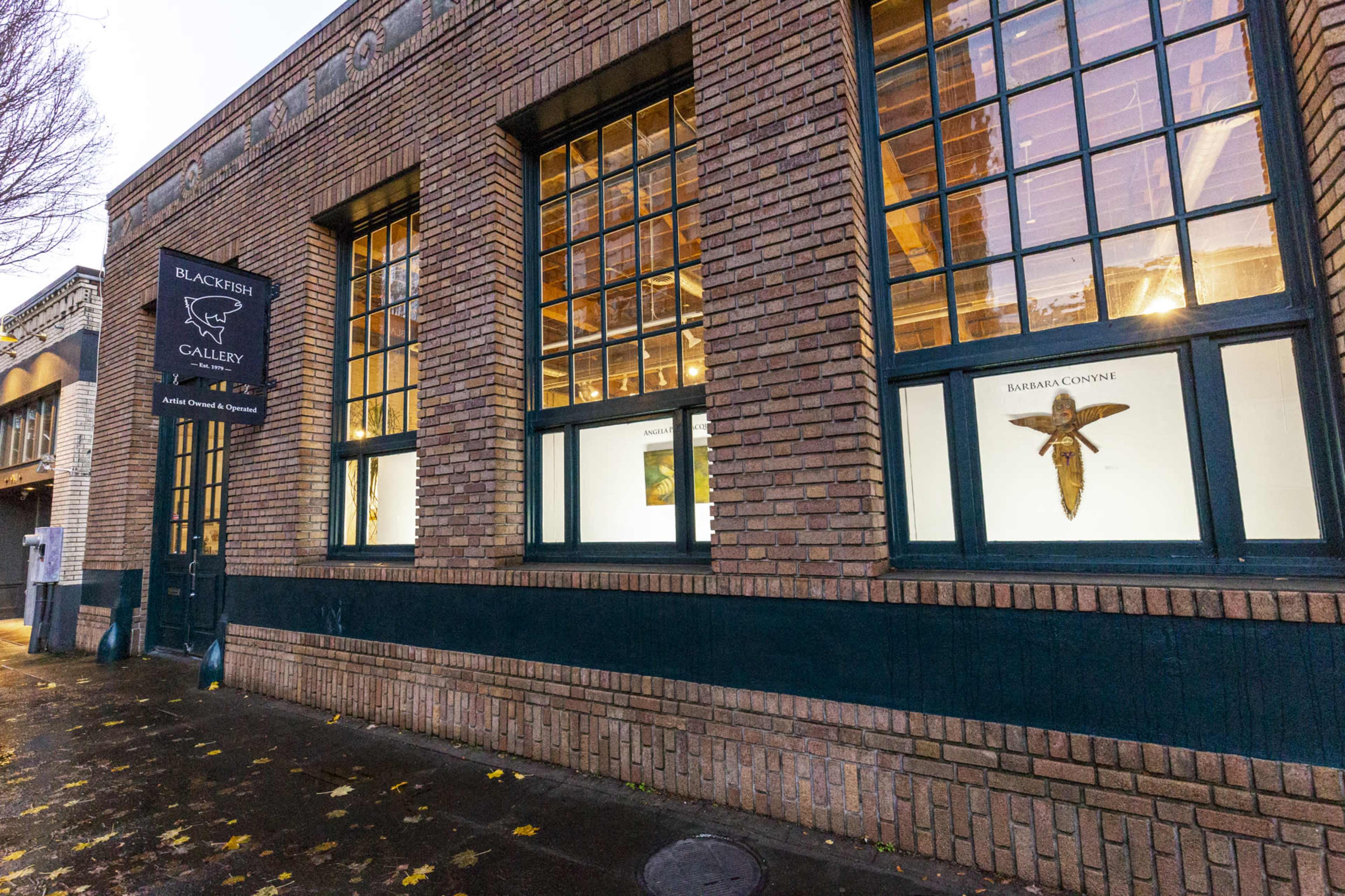 The image shows a brick building with large windows and a sign for the Blackfish Gallery.