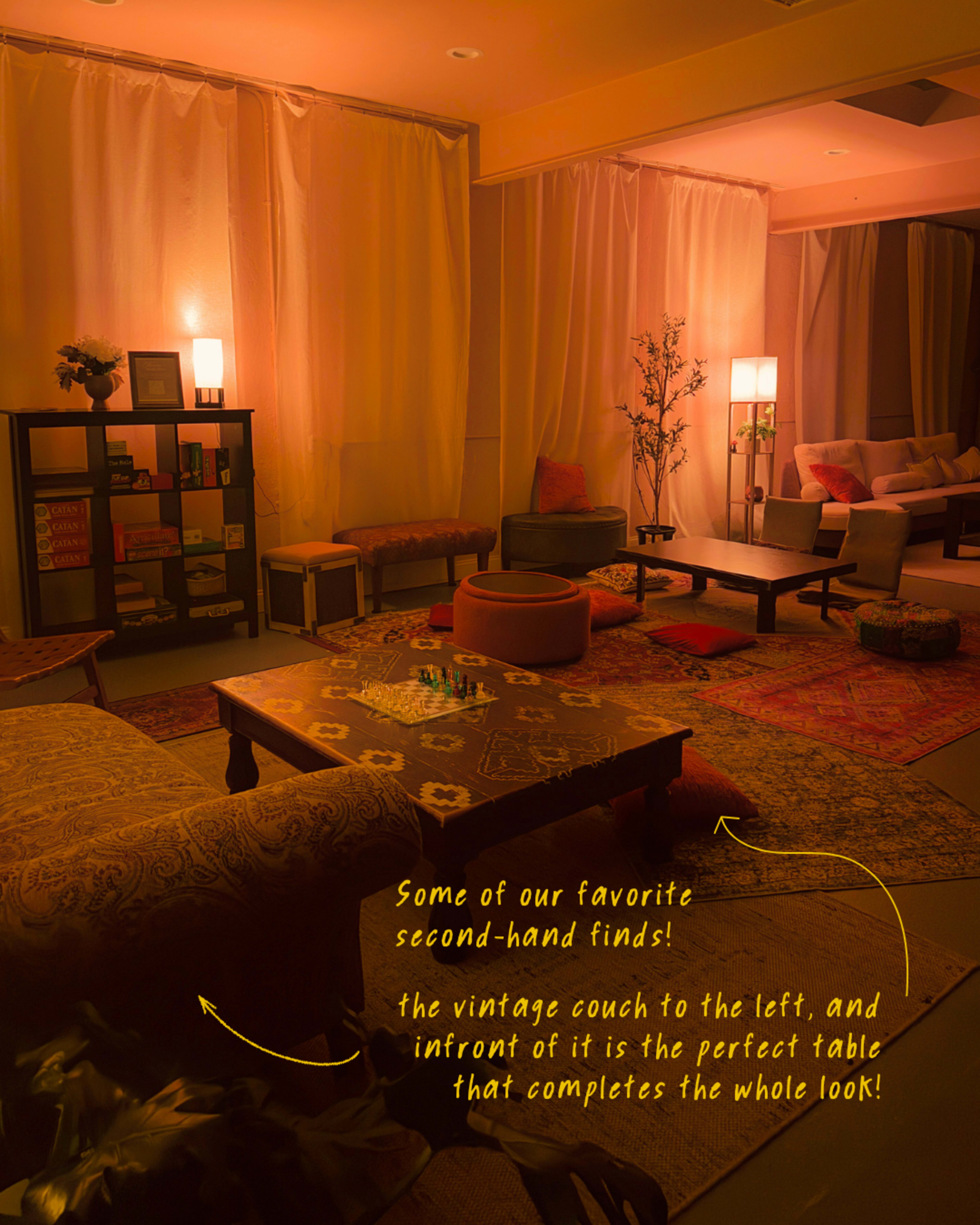 The image depicts a dimly lit living room featuring a mix of vintage furniture, including a couch and a patterned rug, arranged around low tables.