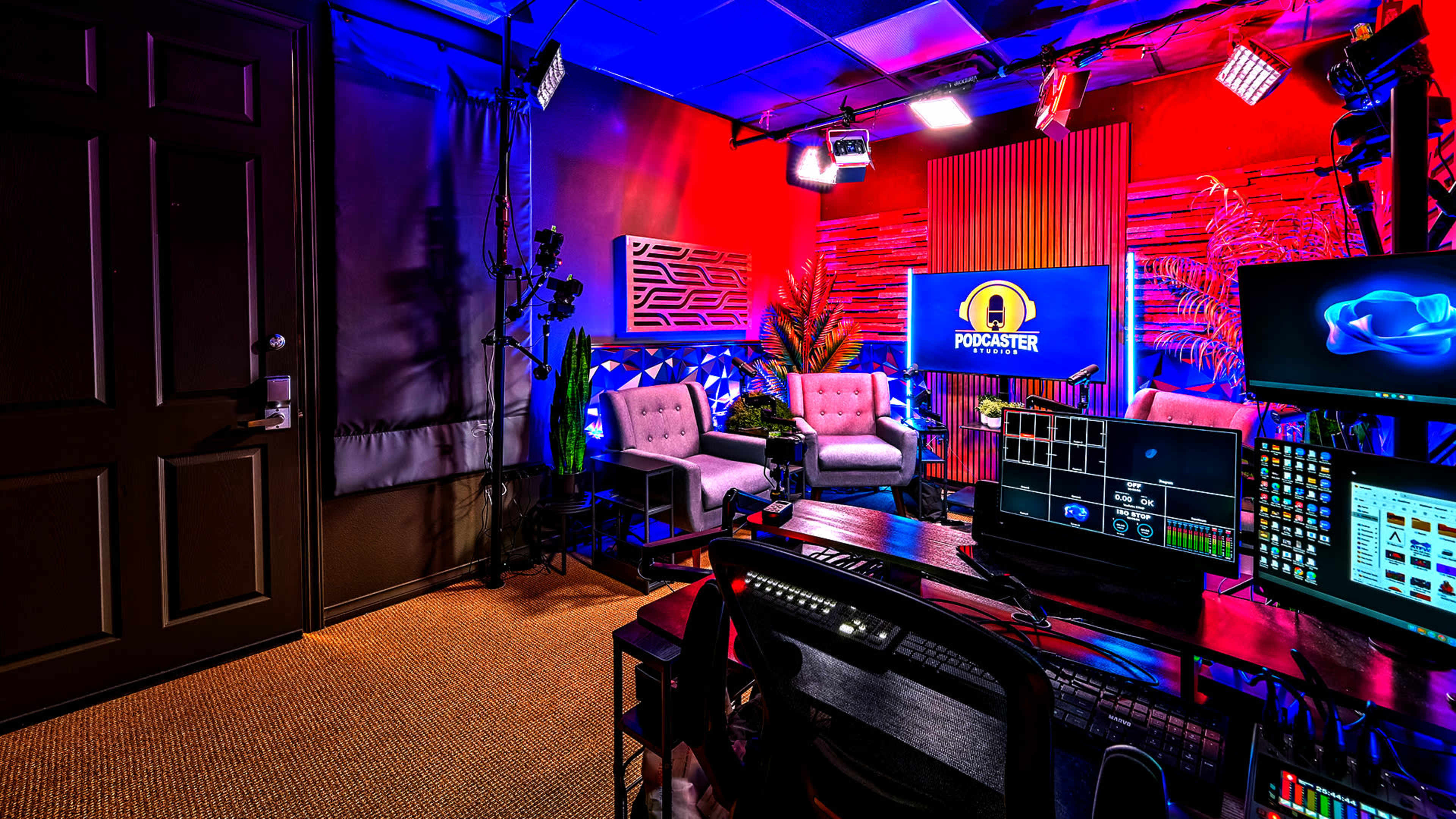 The image shows a vibrant podcast studio equipped with multiple cameras, a large screen displaying the podcast logo, and comfortable seating arranged against a backdrop of colorful lighting and decorative elements.