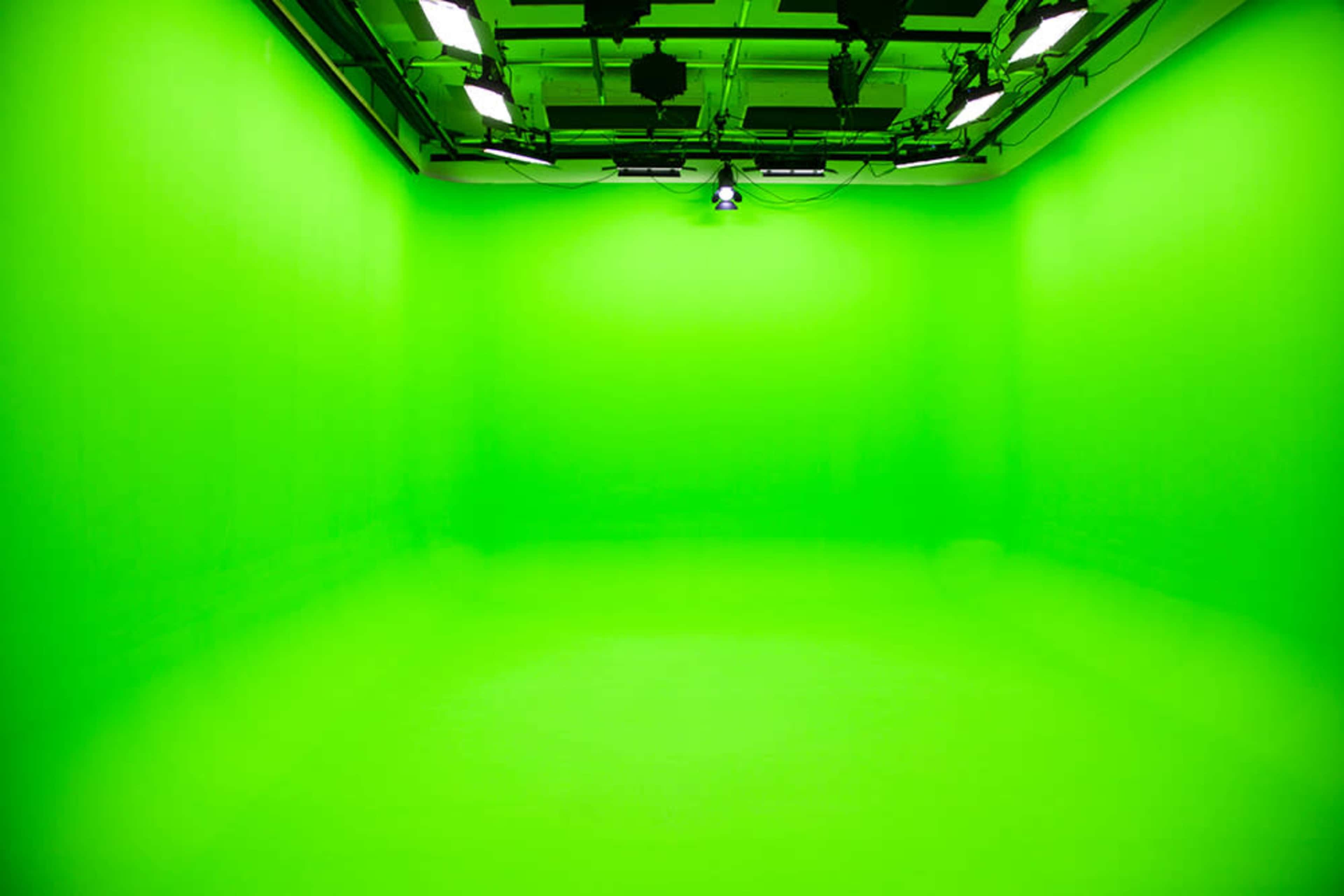 A large green screen studio with evenly lit walls and floor.