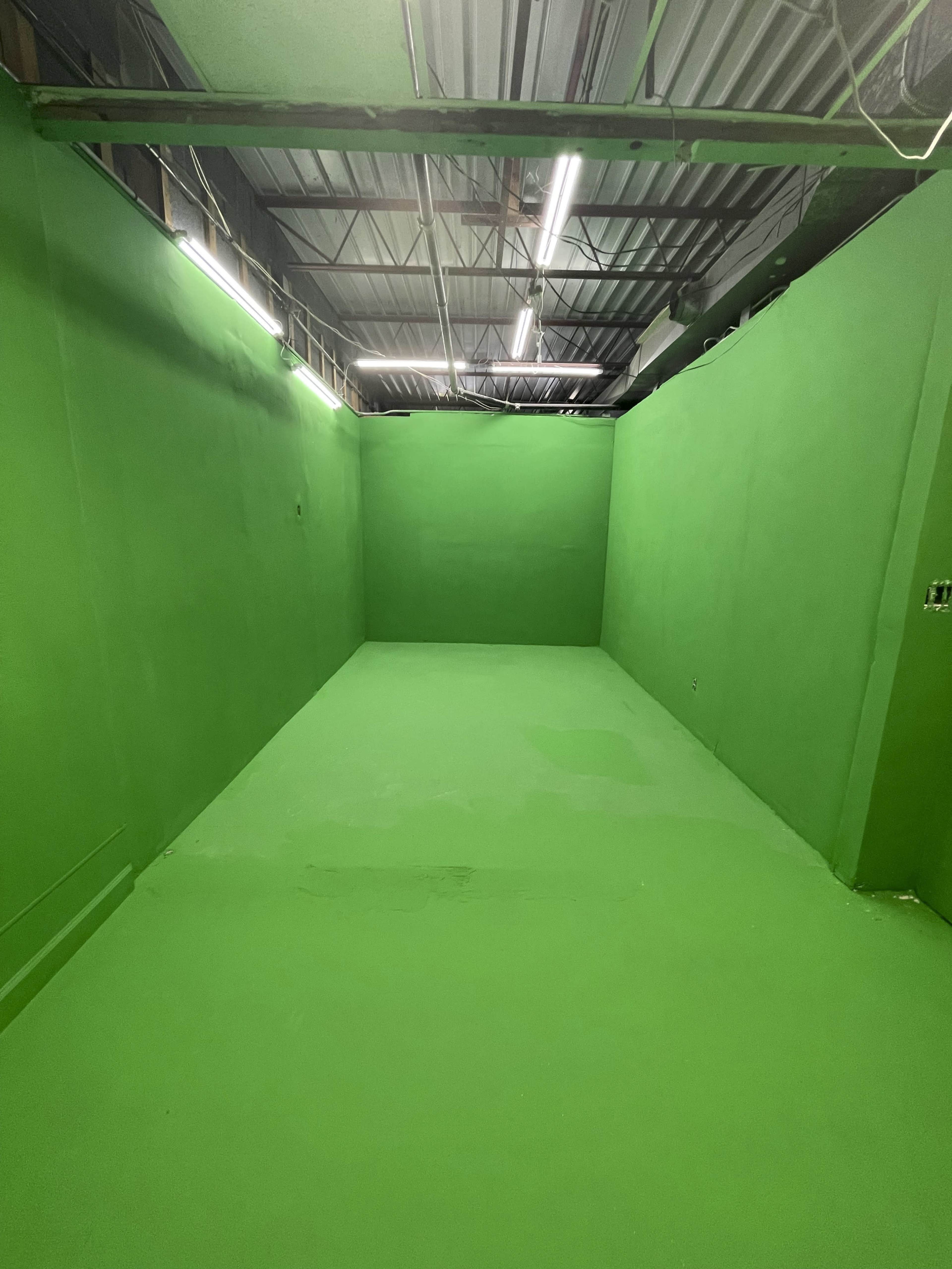 An empty room with all walls, floor, and ceiling painted bright green.