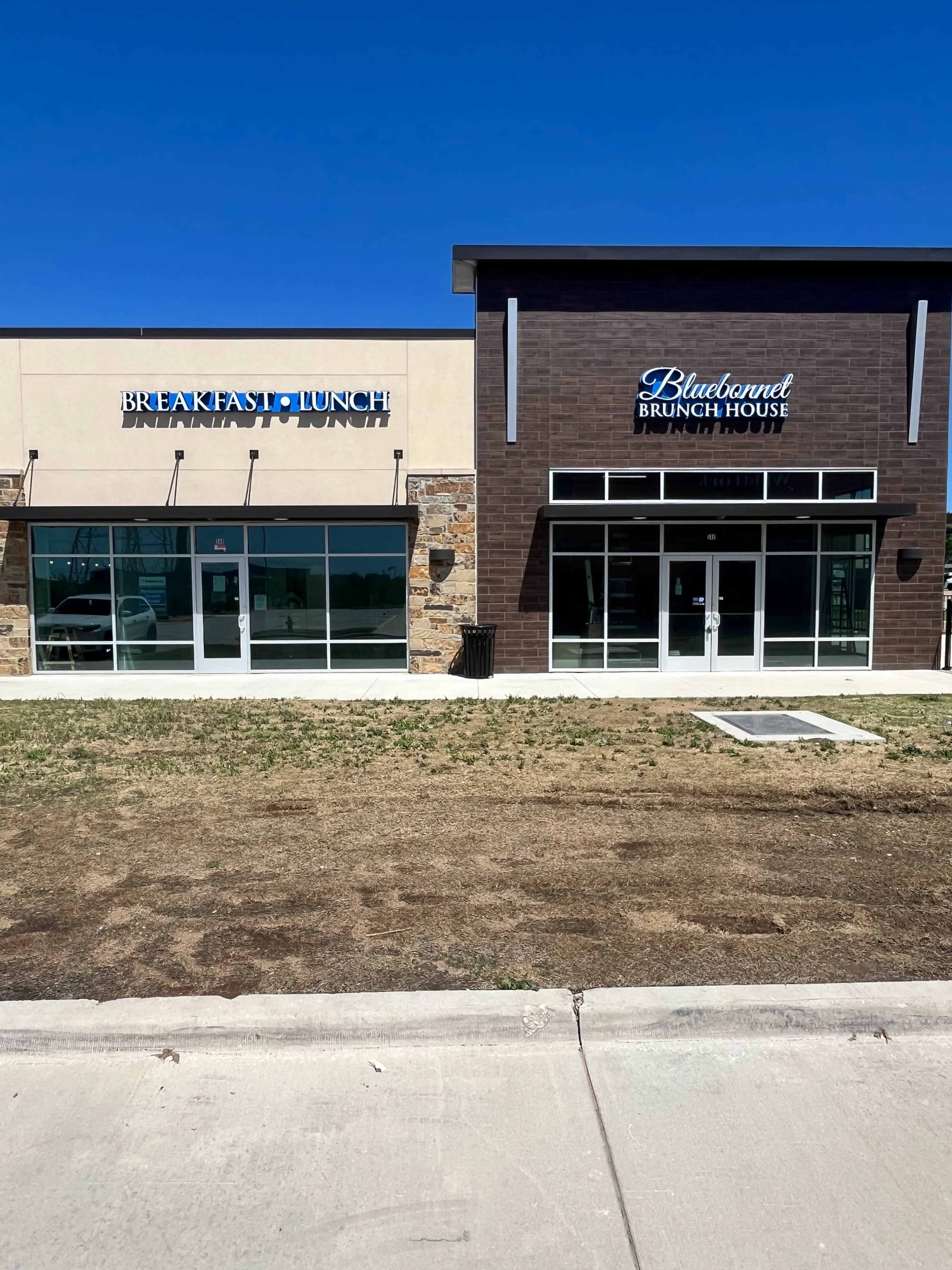 The image shows two adjacent restaurant storefronts, one labeled "Breakfast-Lunch" and the other "Bluebonnet Brunch House," against a clear blue sky.