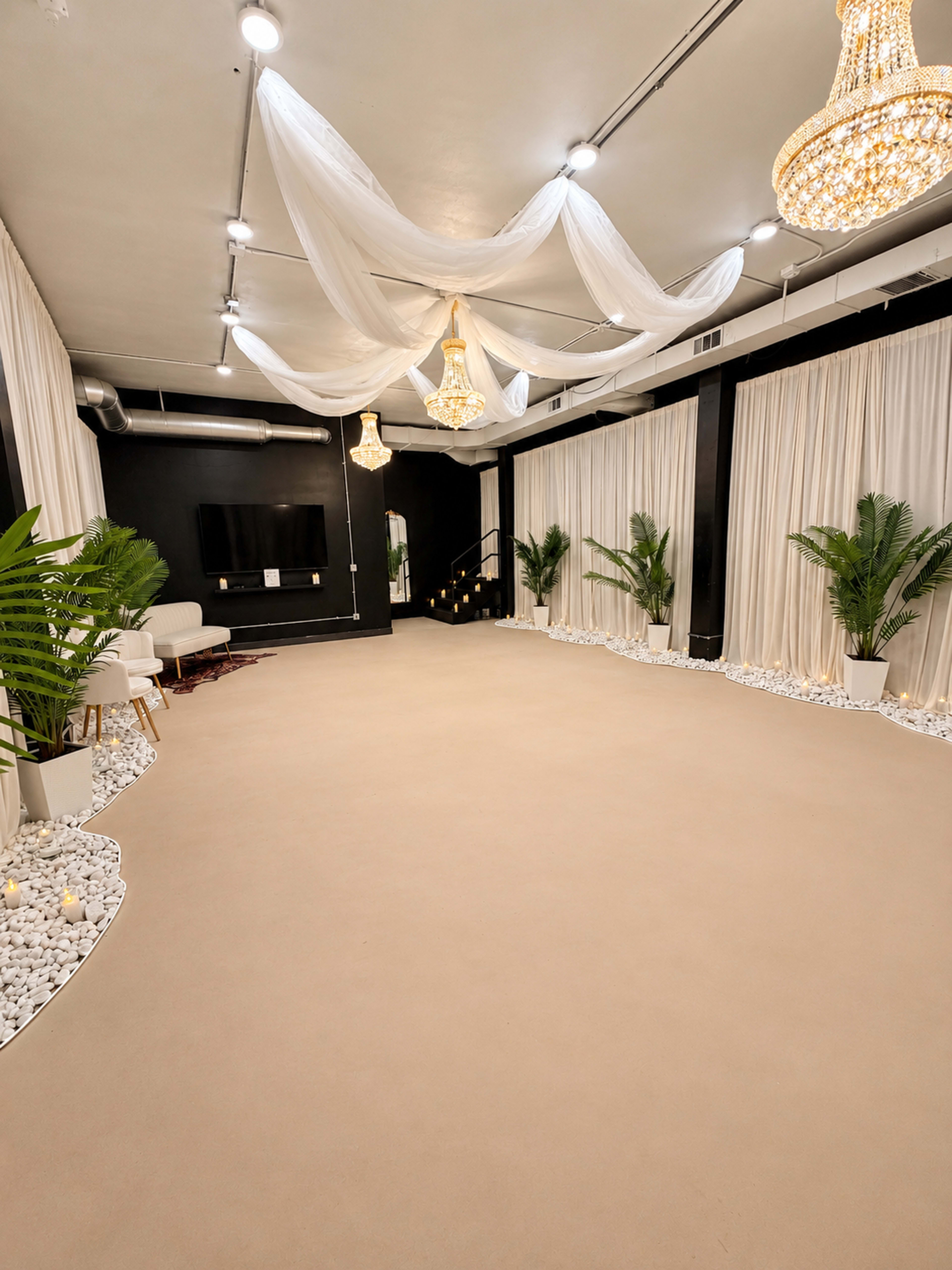 The image shows an elegant interior space featuring crystal chandeliers, white drapery, potted plants, and a smooth, light-colored floor.