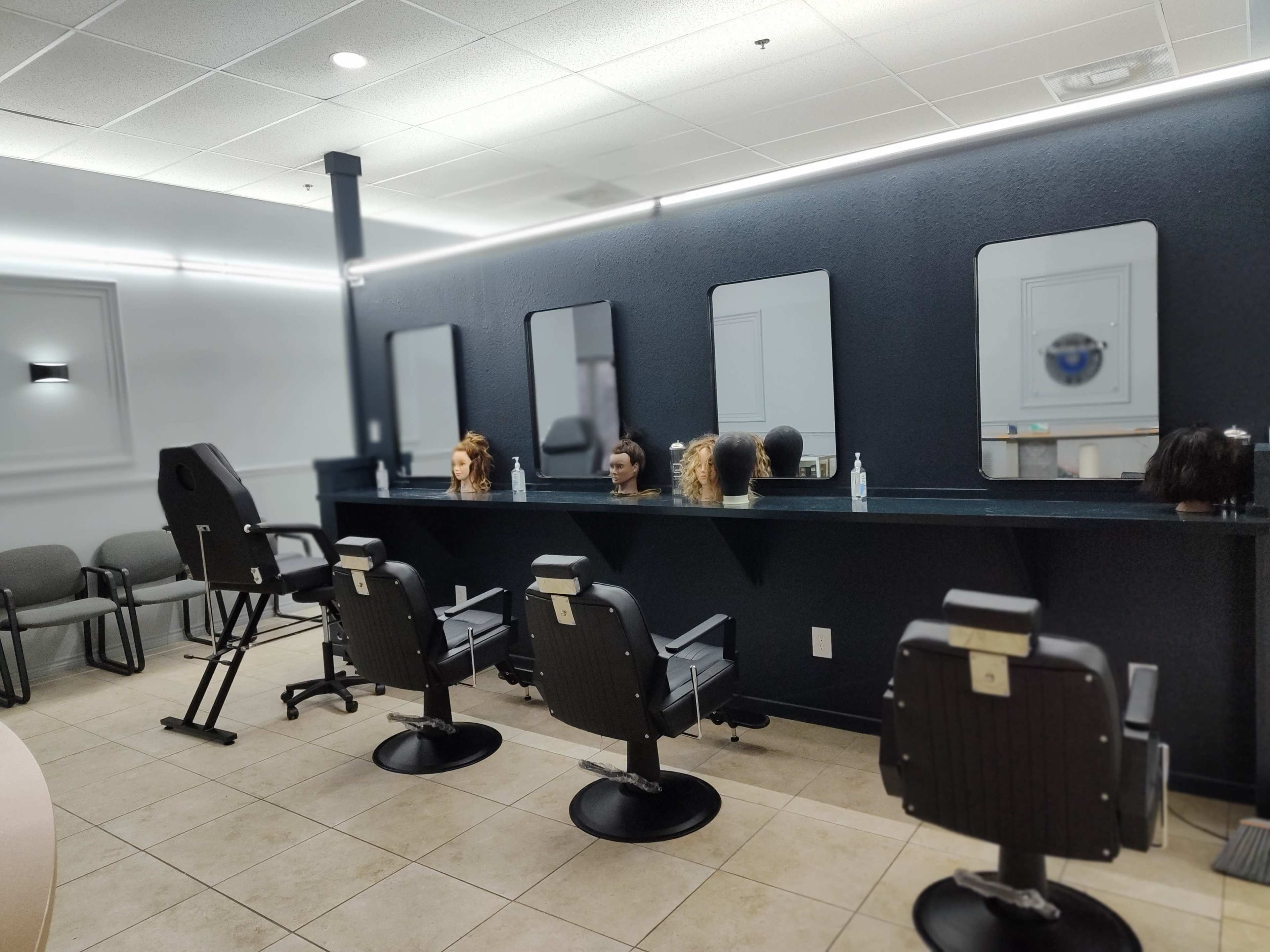 A modern hair salon with several styling stations featuring mirrors and mannequin heads.