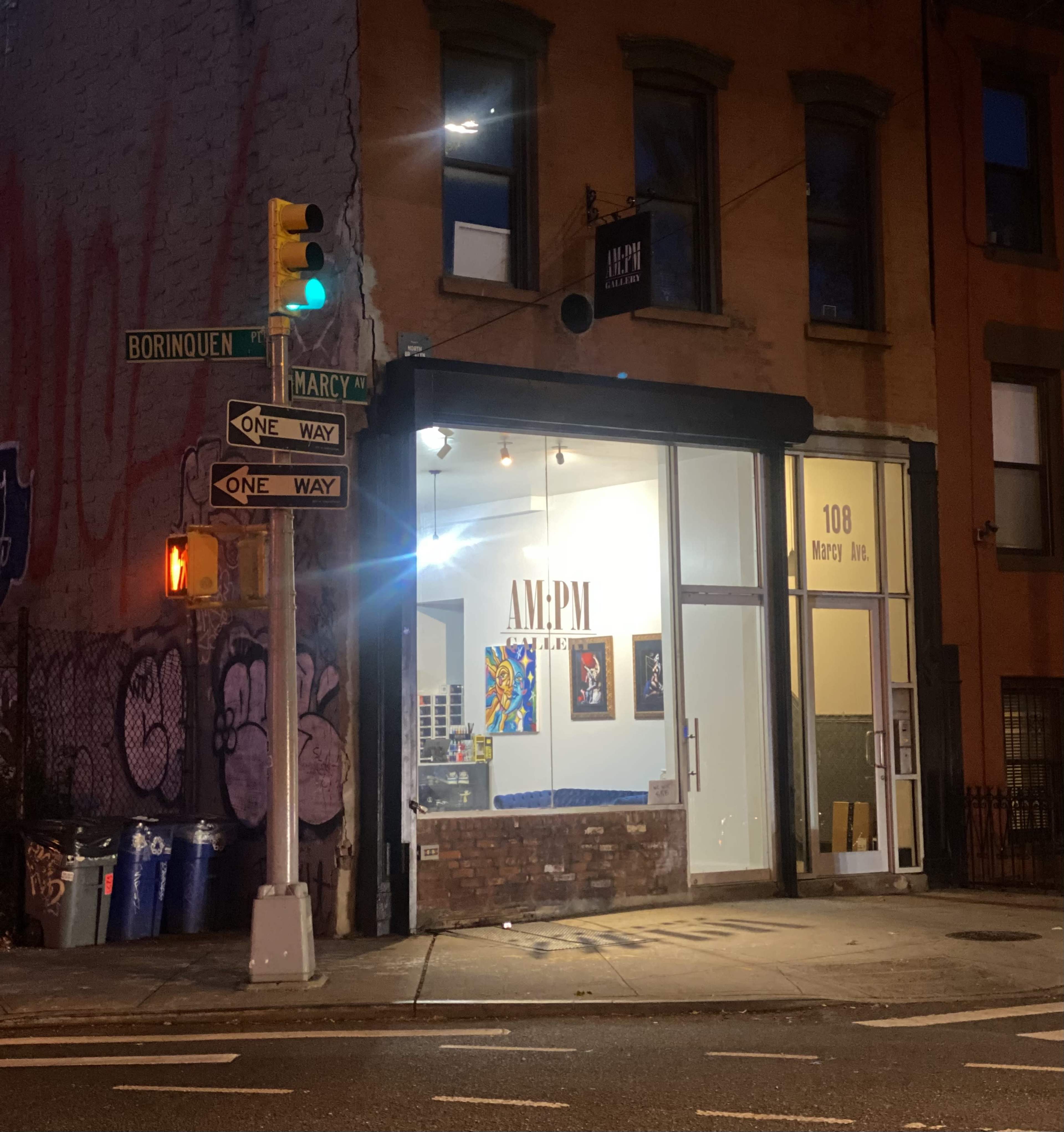 The image shows a gallery storefront with large windows displaying artwork, located at 108 Marcy Ave, next to a street sign indicating "Borinquen" and "One Way."