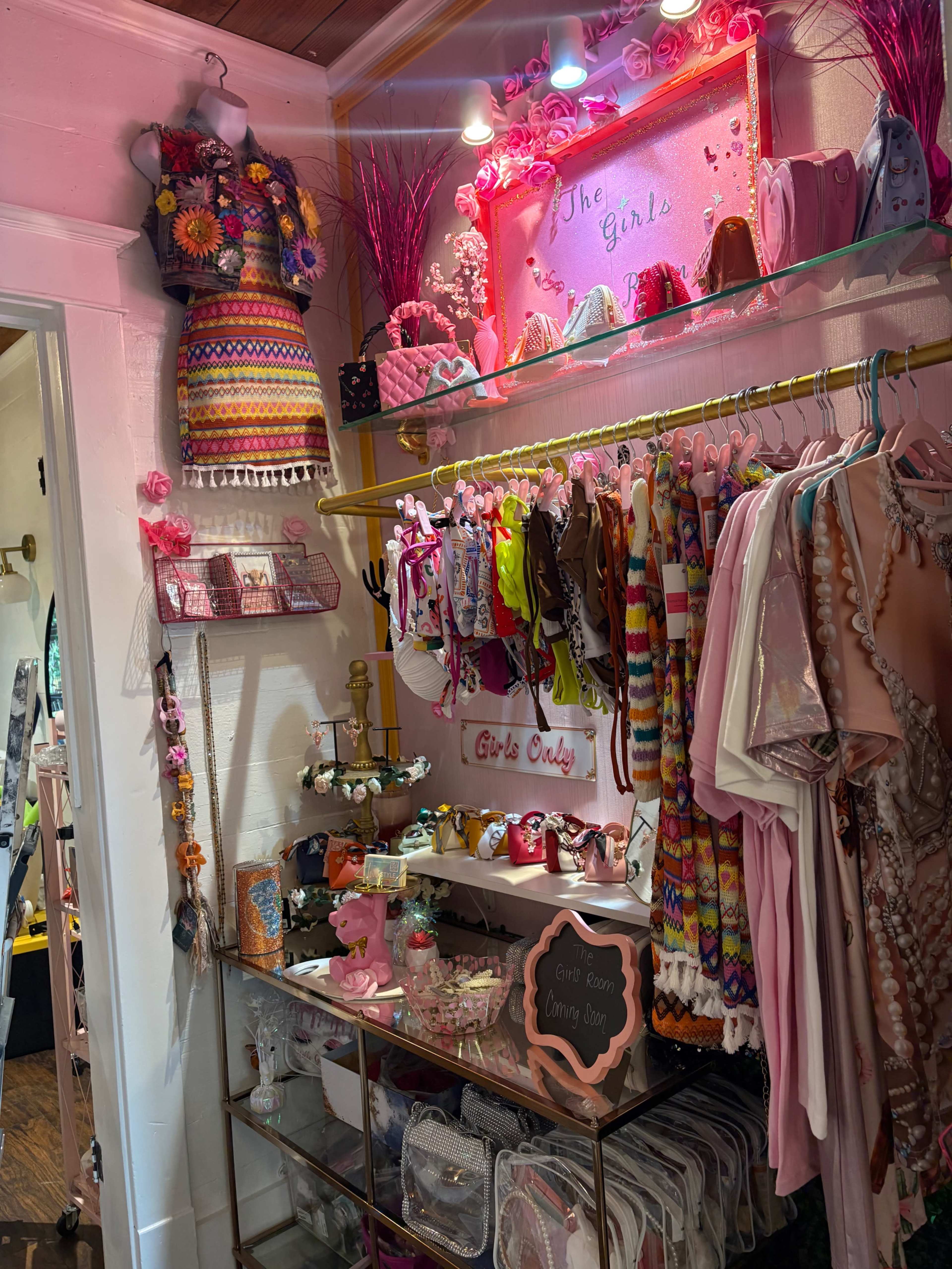 A boutique display showcases colorful children's clothing and accessories, arranged on racks and shelves with decorative elements.