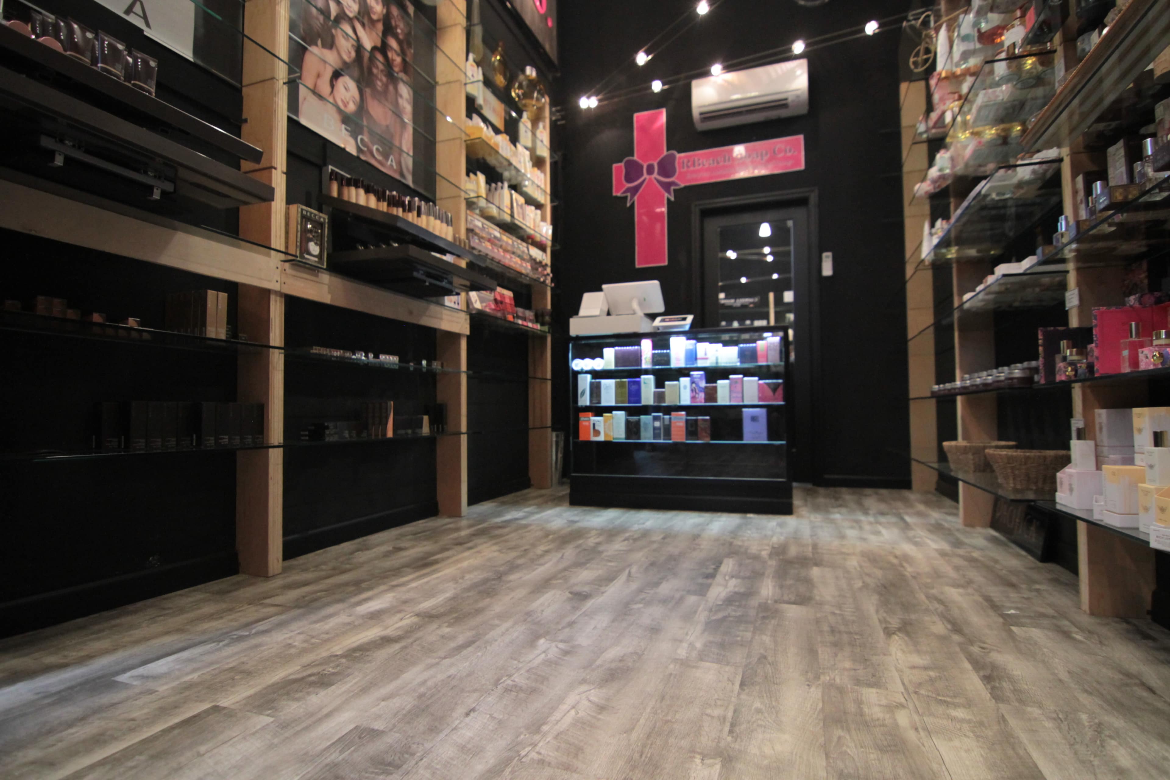 The interior of a retail store displaying various beauty products on shelves and a checkout counter in the background.