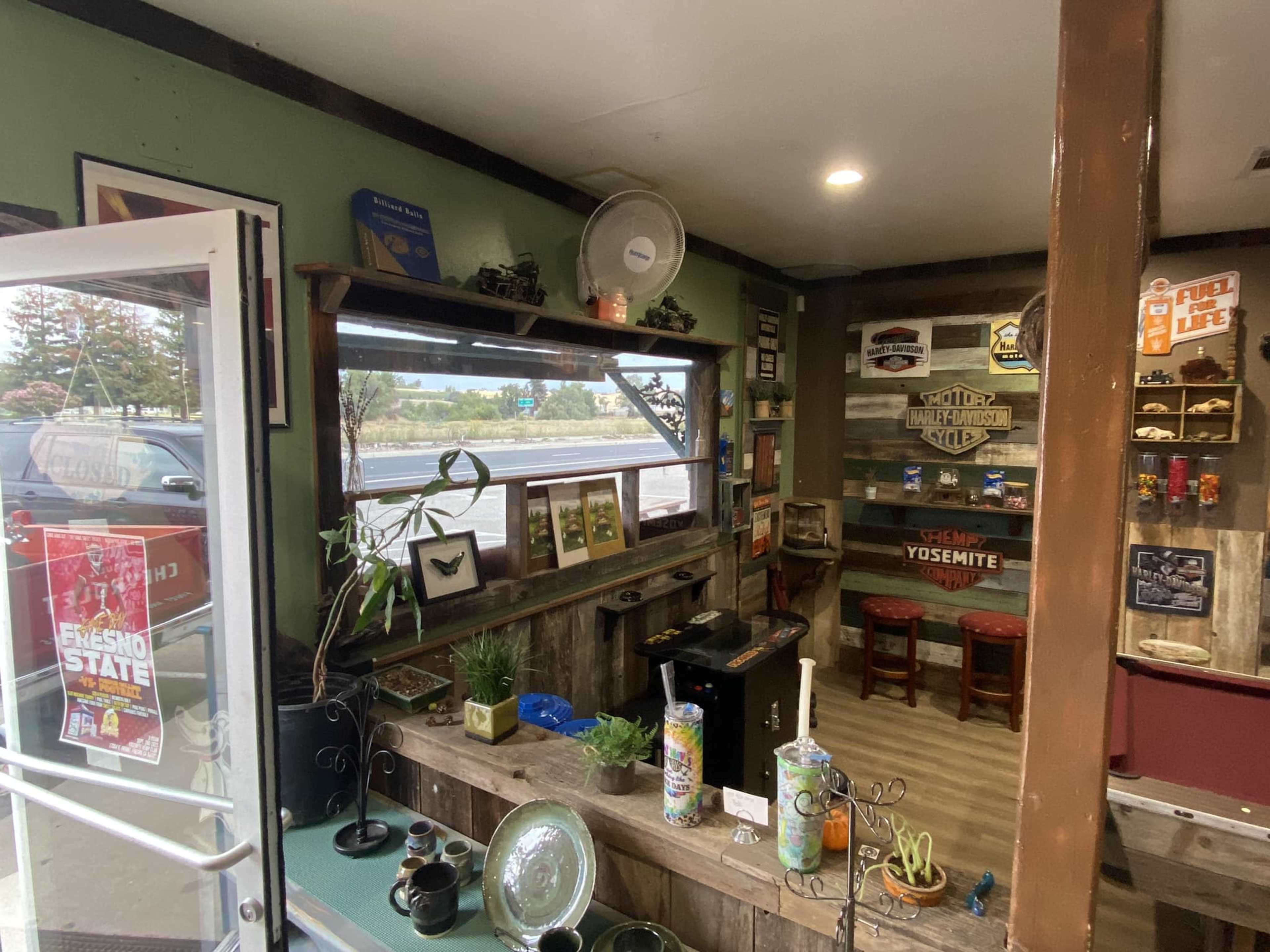 The scene shows a small interior space with decorated walls, a counter, and a view of a window facing a parking lot.