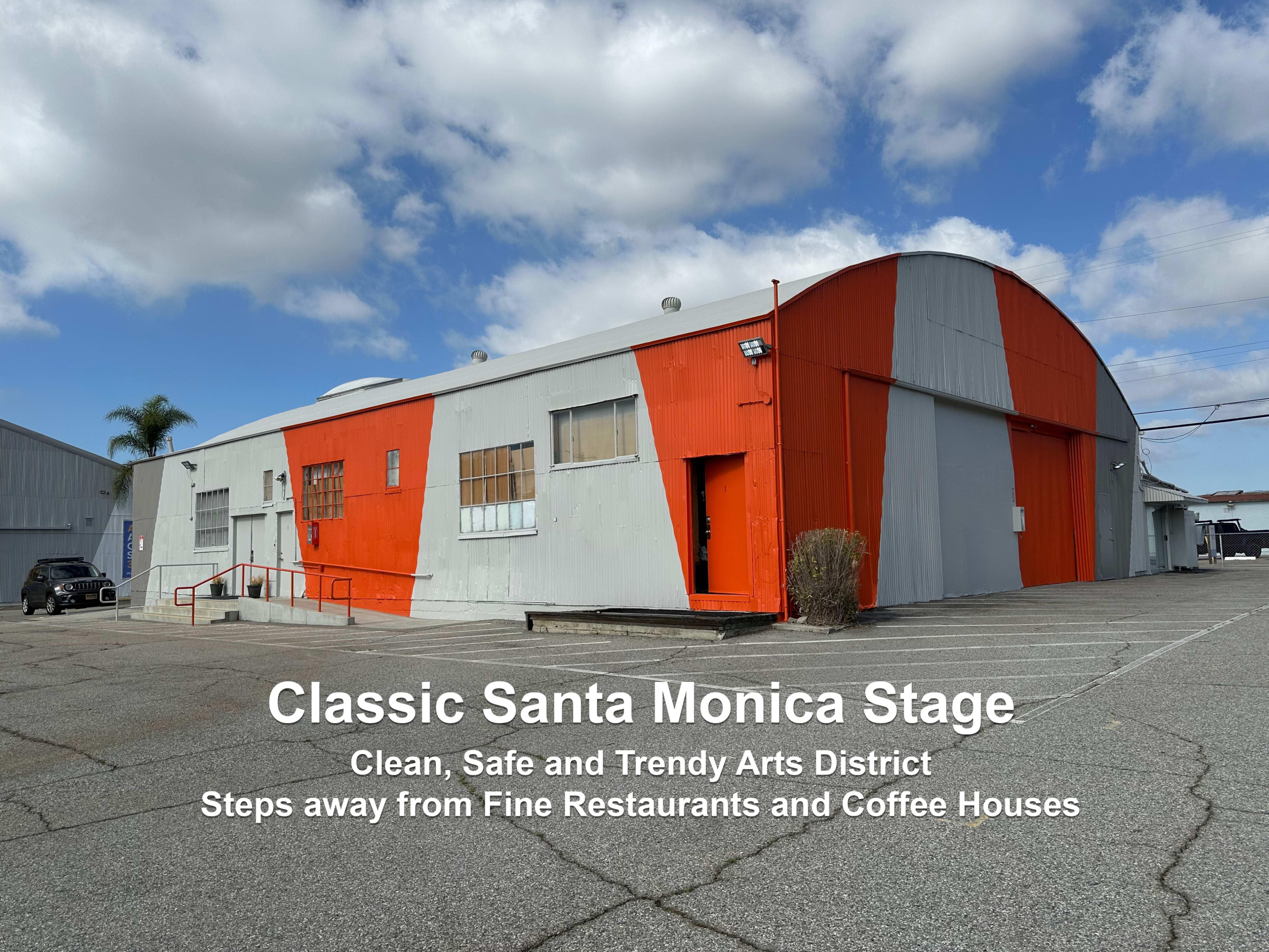 The image shows a building with a red and gray facade, set in a parking lot, with text promoting the Santa Monica Stage and its proximity to restaurants and coffee houses.