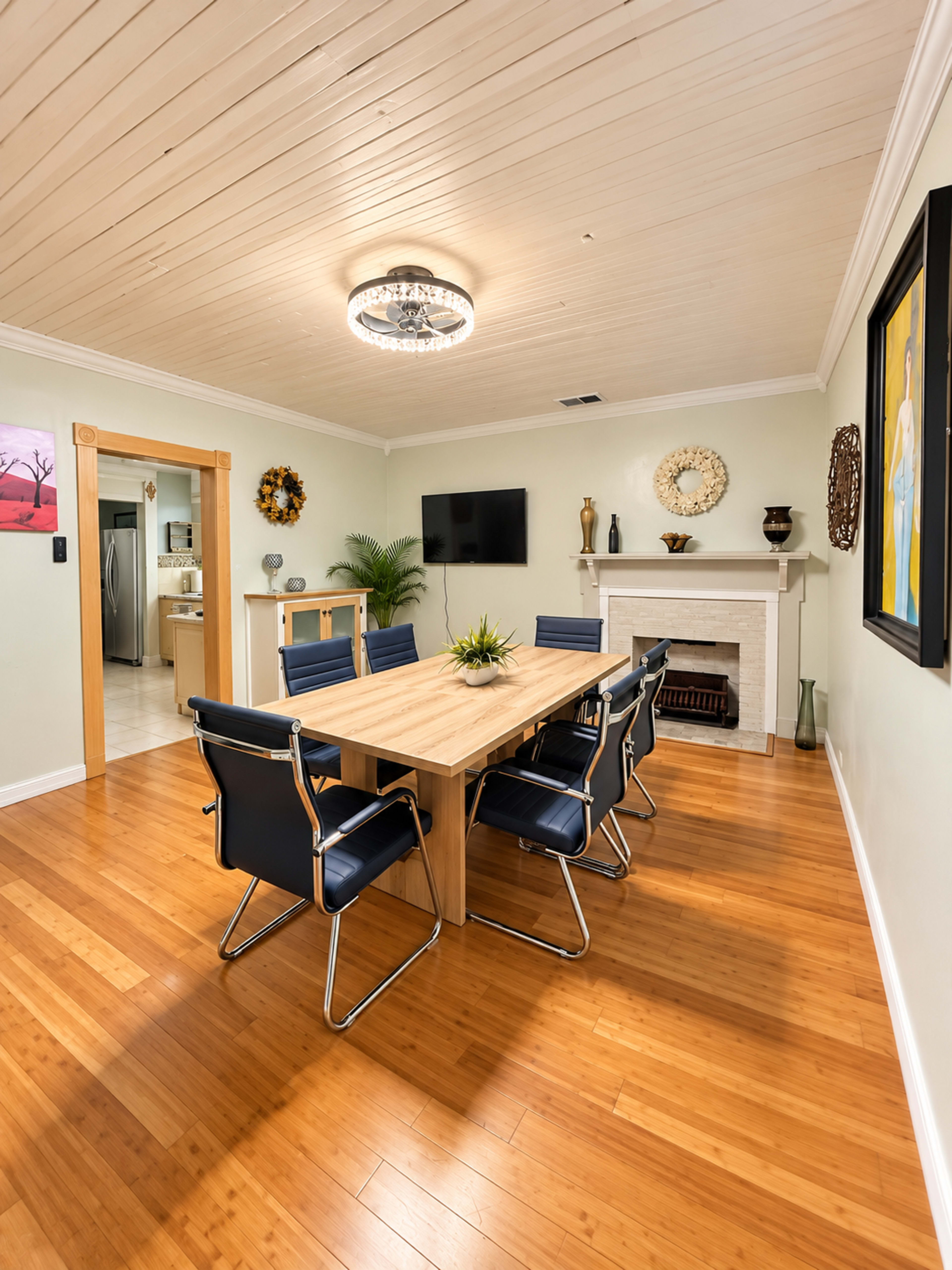 The image shows a dining area with a wooden table surrounded by black chairs, hardwood flooring, and a decorative fireplace.