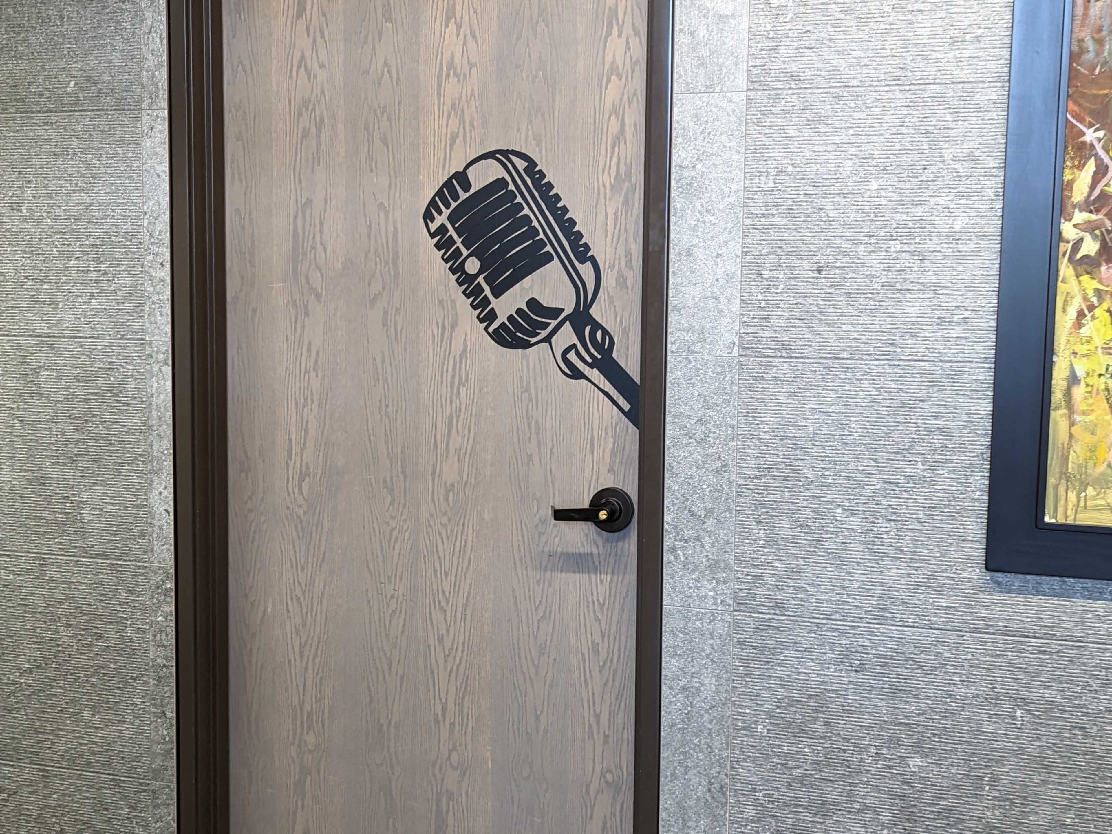 A wooden door with a black microphone graphic on its surface.