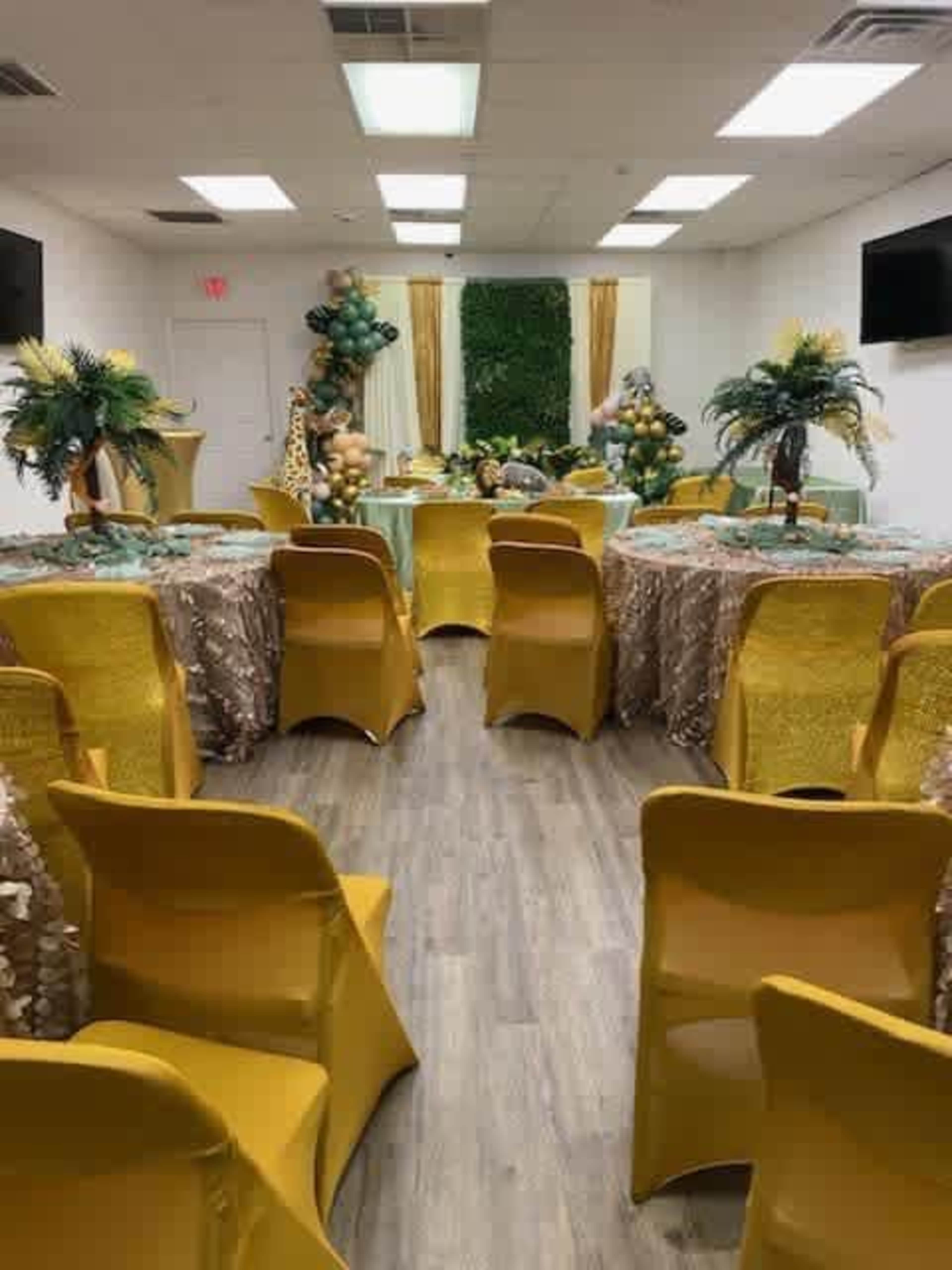 A banquet hall set up for an event, featuring tables with decorative tablecloths and yellow chairs arranged in a symmetrical layout.