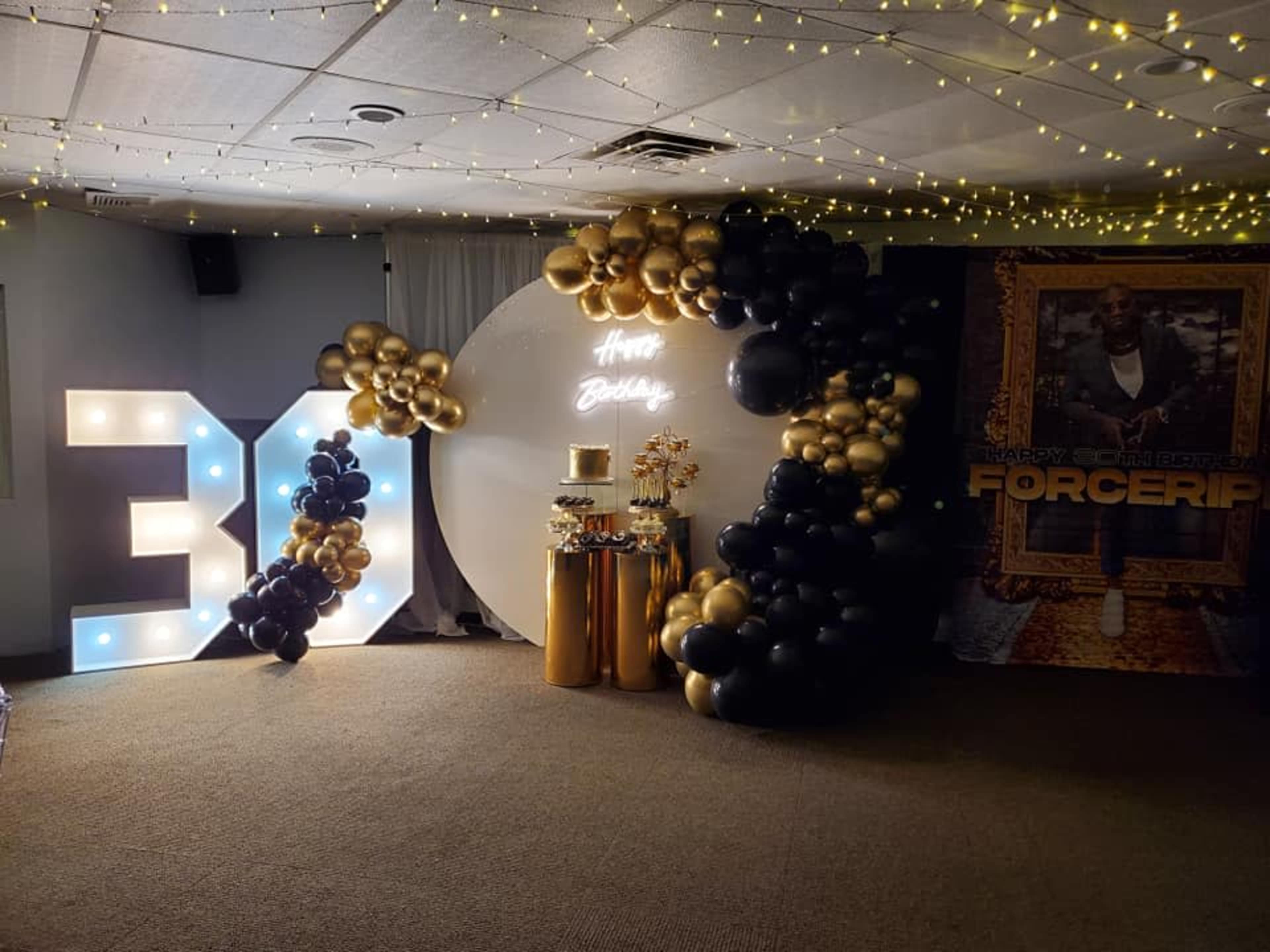 The scene features a decorated area for a 30th birthday celebration with large illuminated "30" numbers, a circular backdrop, and a balloon display in black and gold.