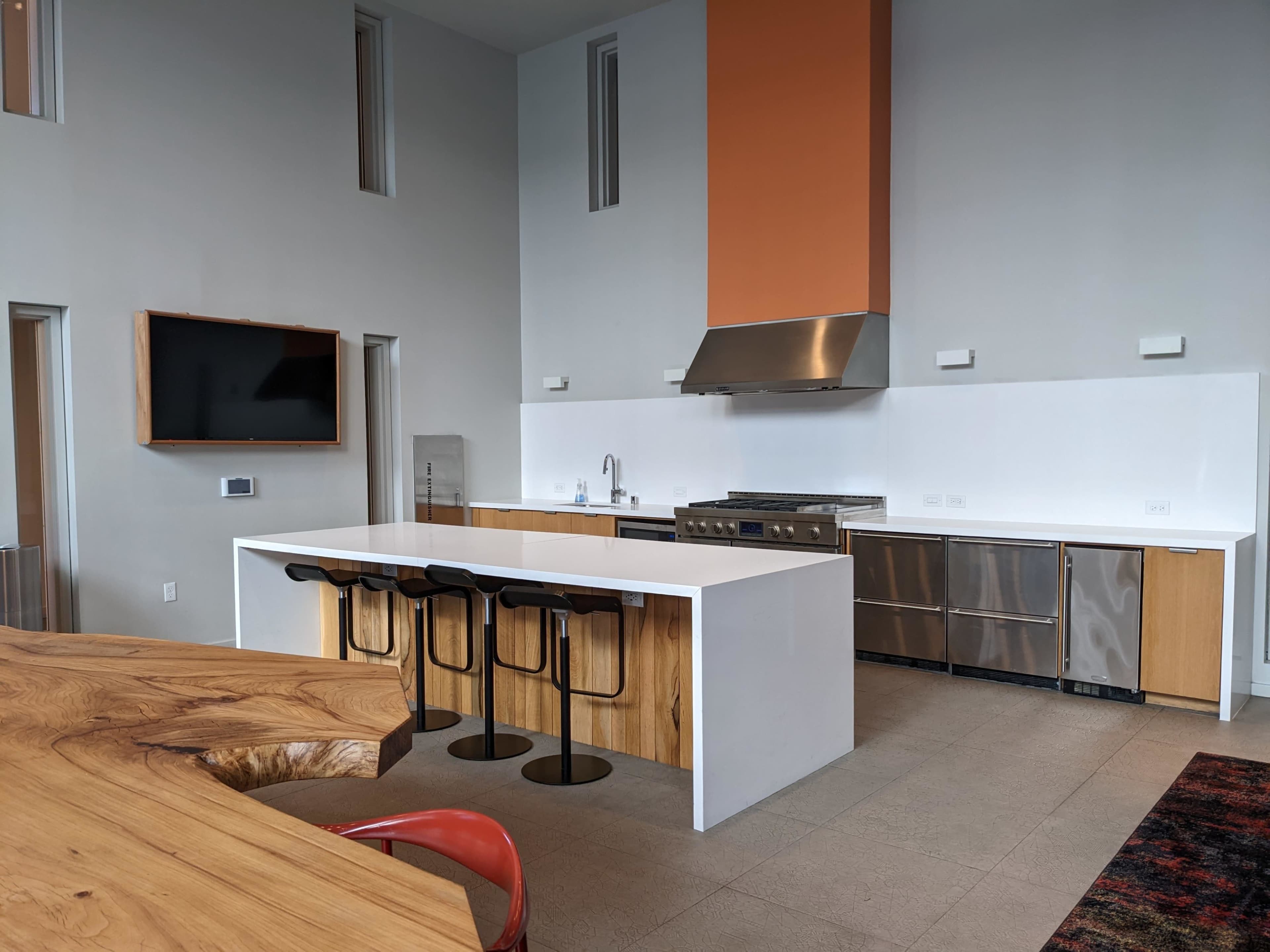 A modern kitchen with a large island, stainless steel appliances, and a minimalist design.