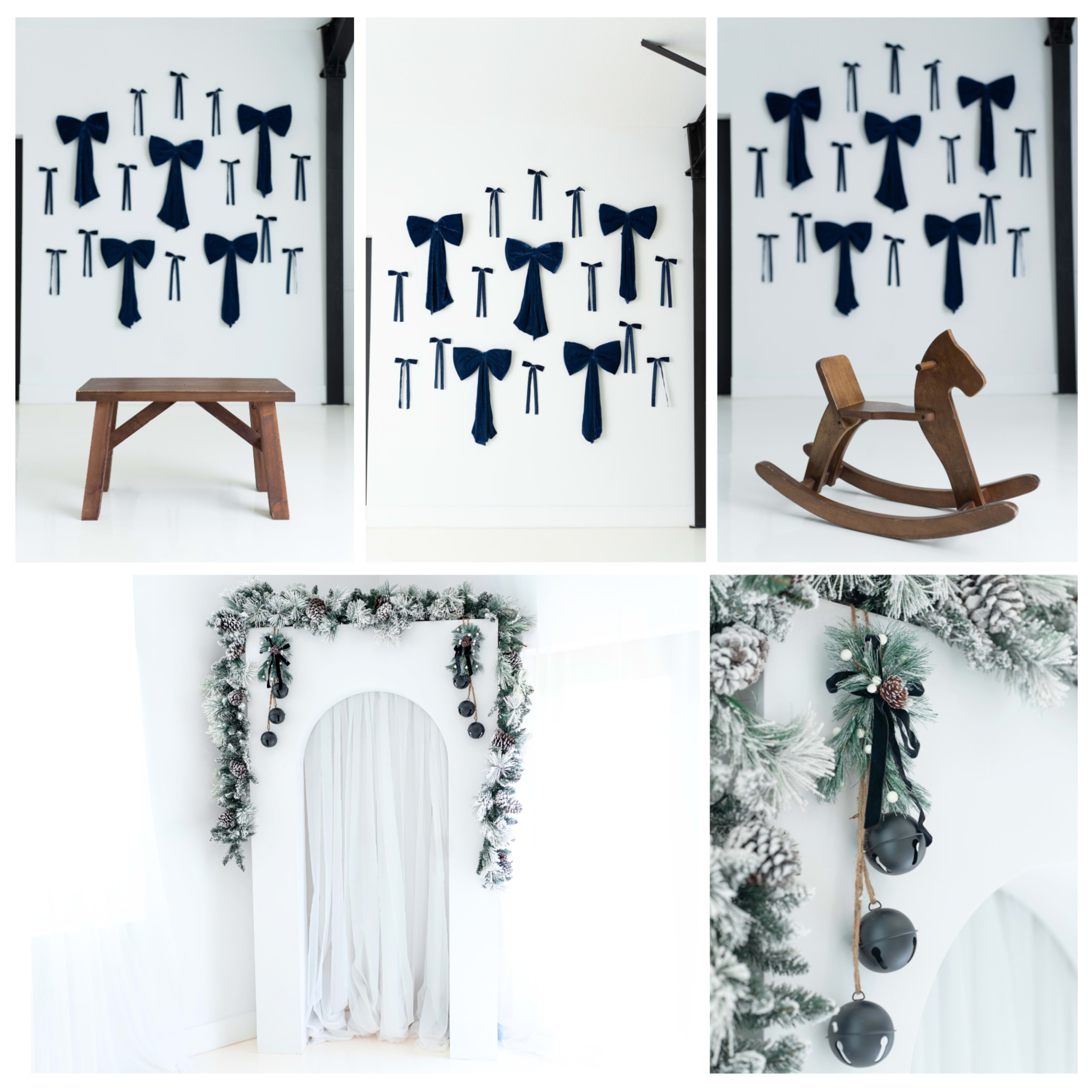 The image shows a collection of navy blue bows arranged on a white wall, a wooden table, a rocking horse, and a decorated archway with greenery and bells.