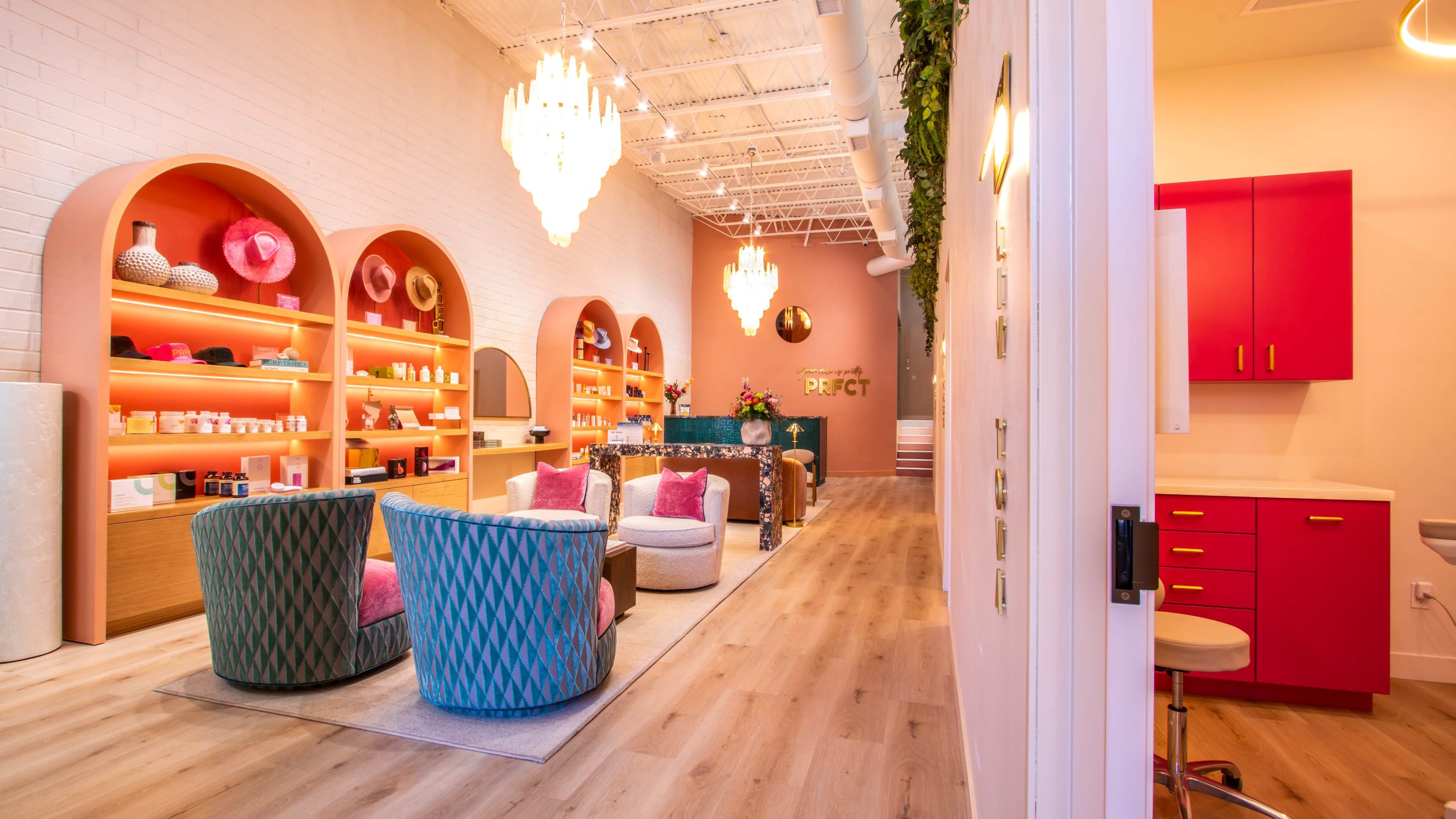The image shows a brightly lit boutique interior featuring colorful seating, decorative shelves, and vibrant accents on the walls.