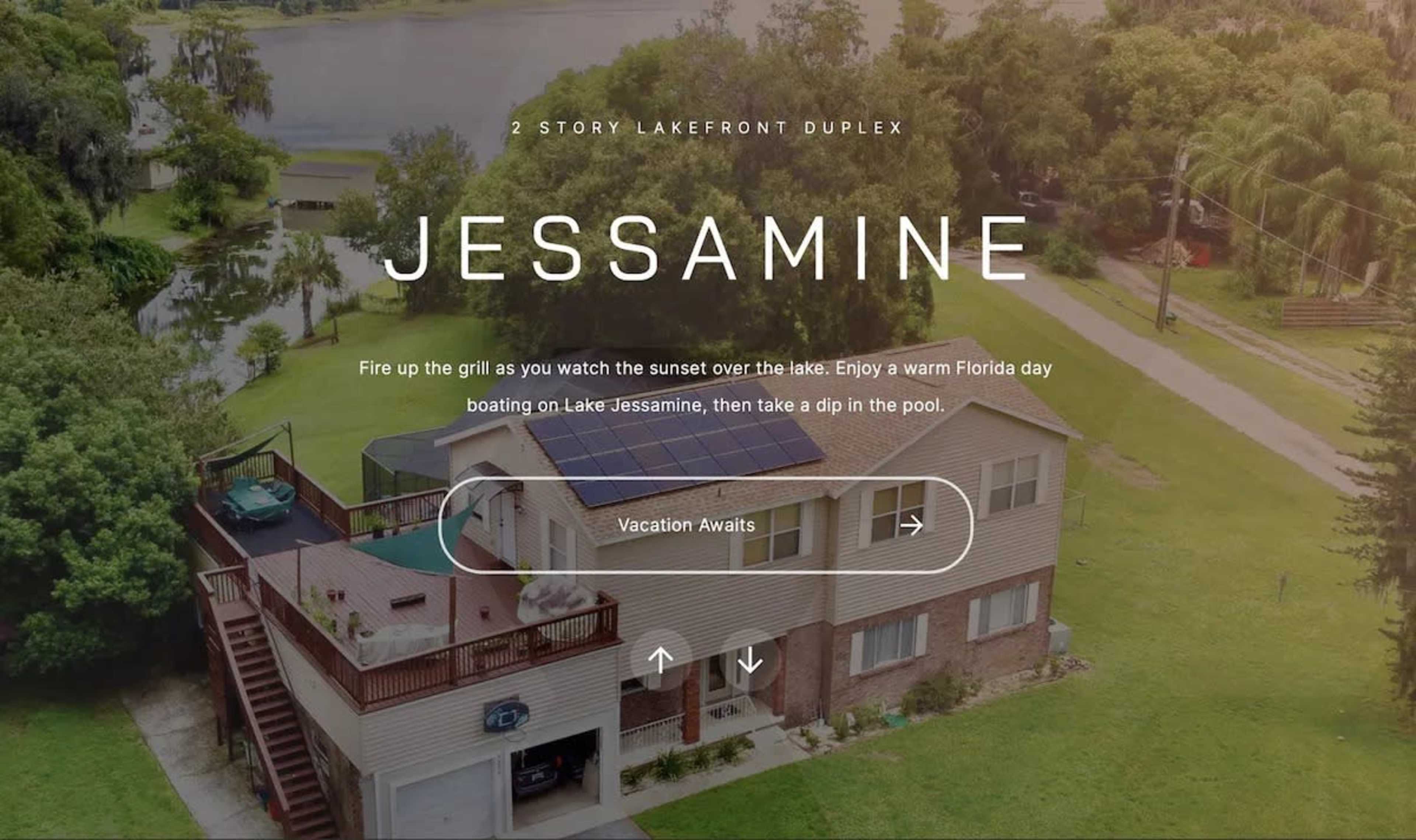 The image shows a two-story duplex located by a lake, featuring a deck and pool in an outdoor setting.