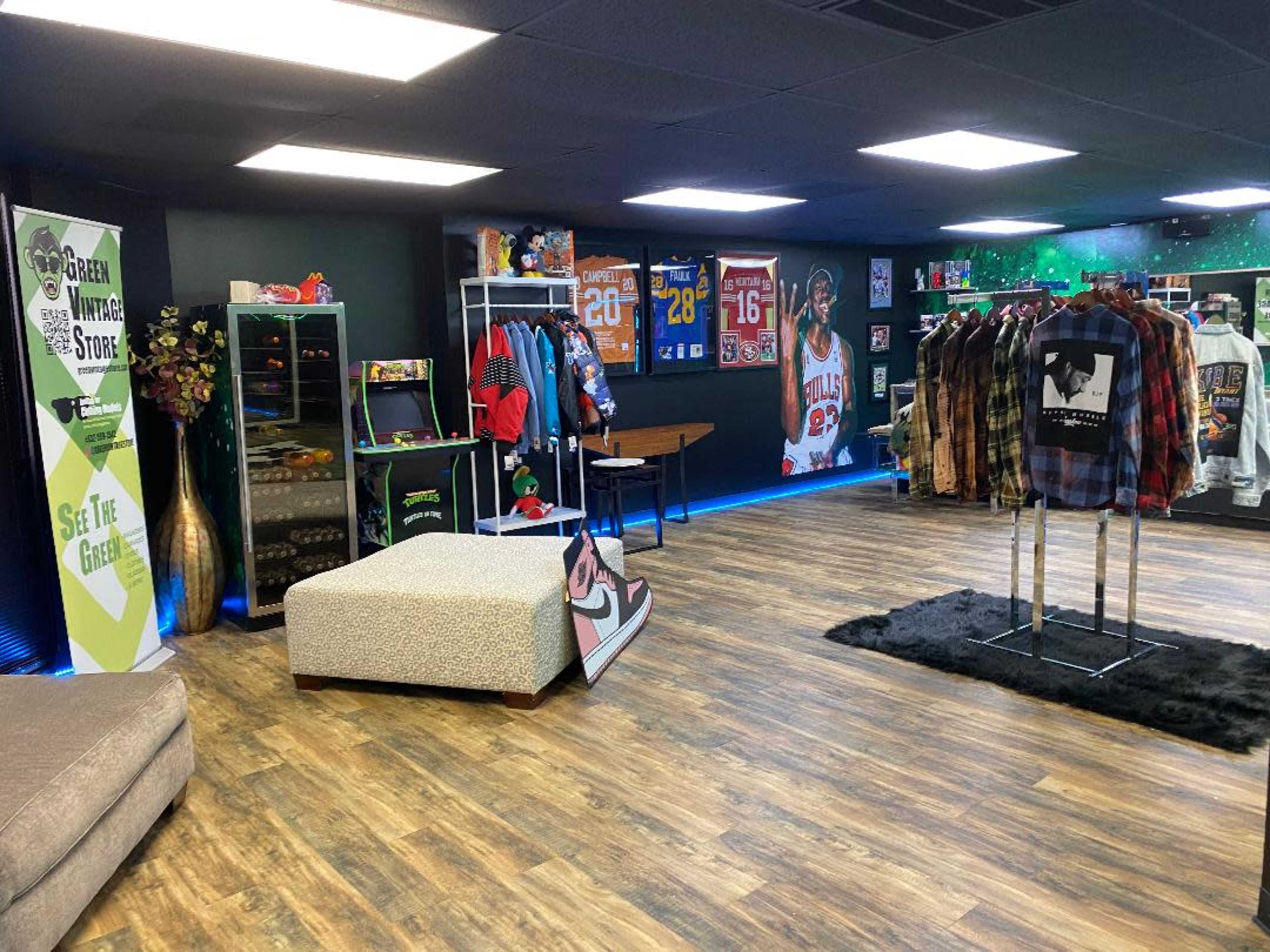 An indoor boutique featuring clothing racks, a seating area, and decorative sports memorabilia on the walls.