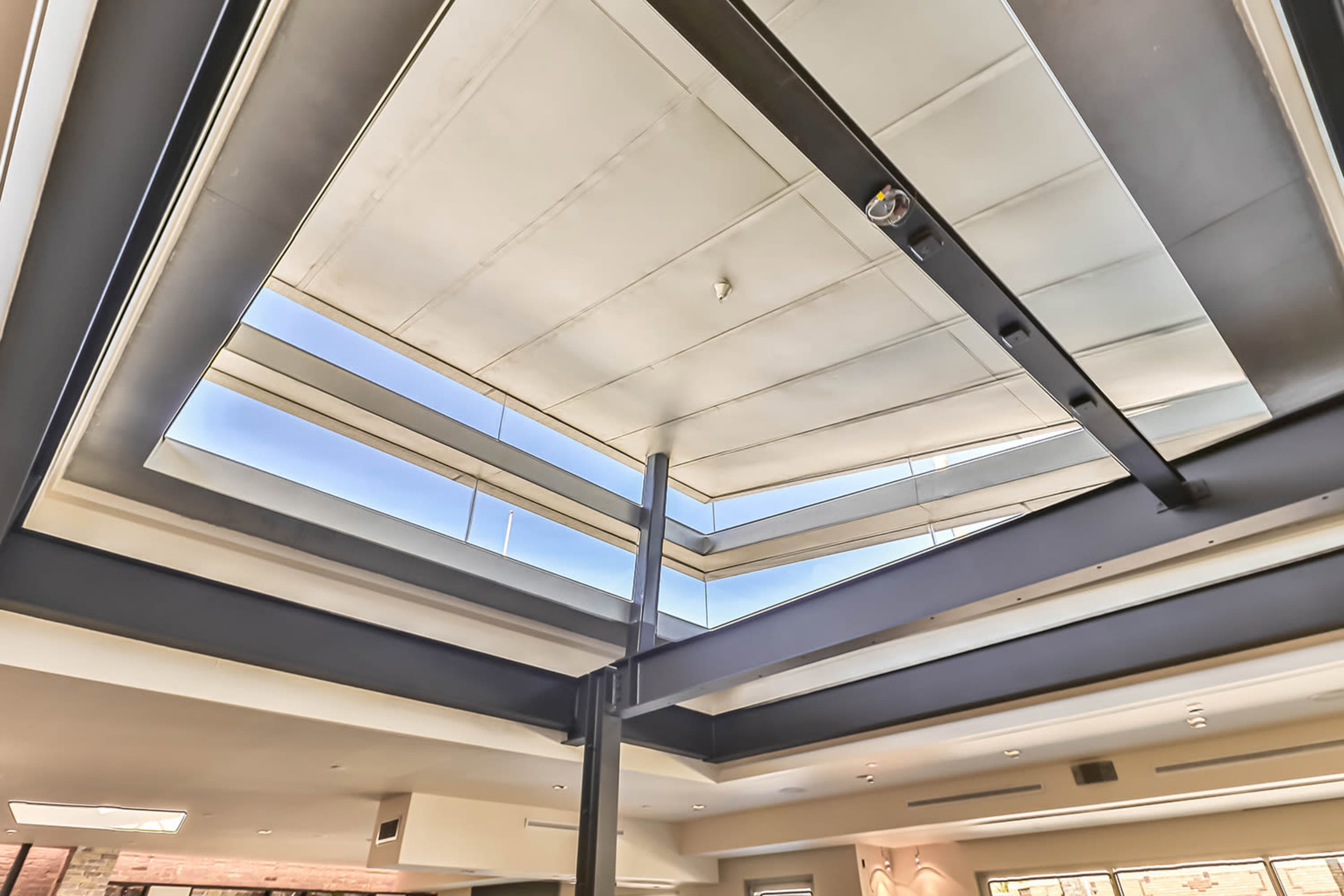 A modern interior space with a multi-layered skylight allowing natural light to enter.