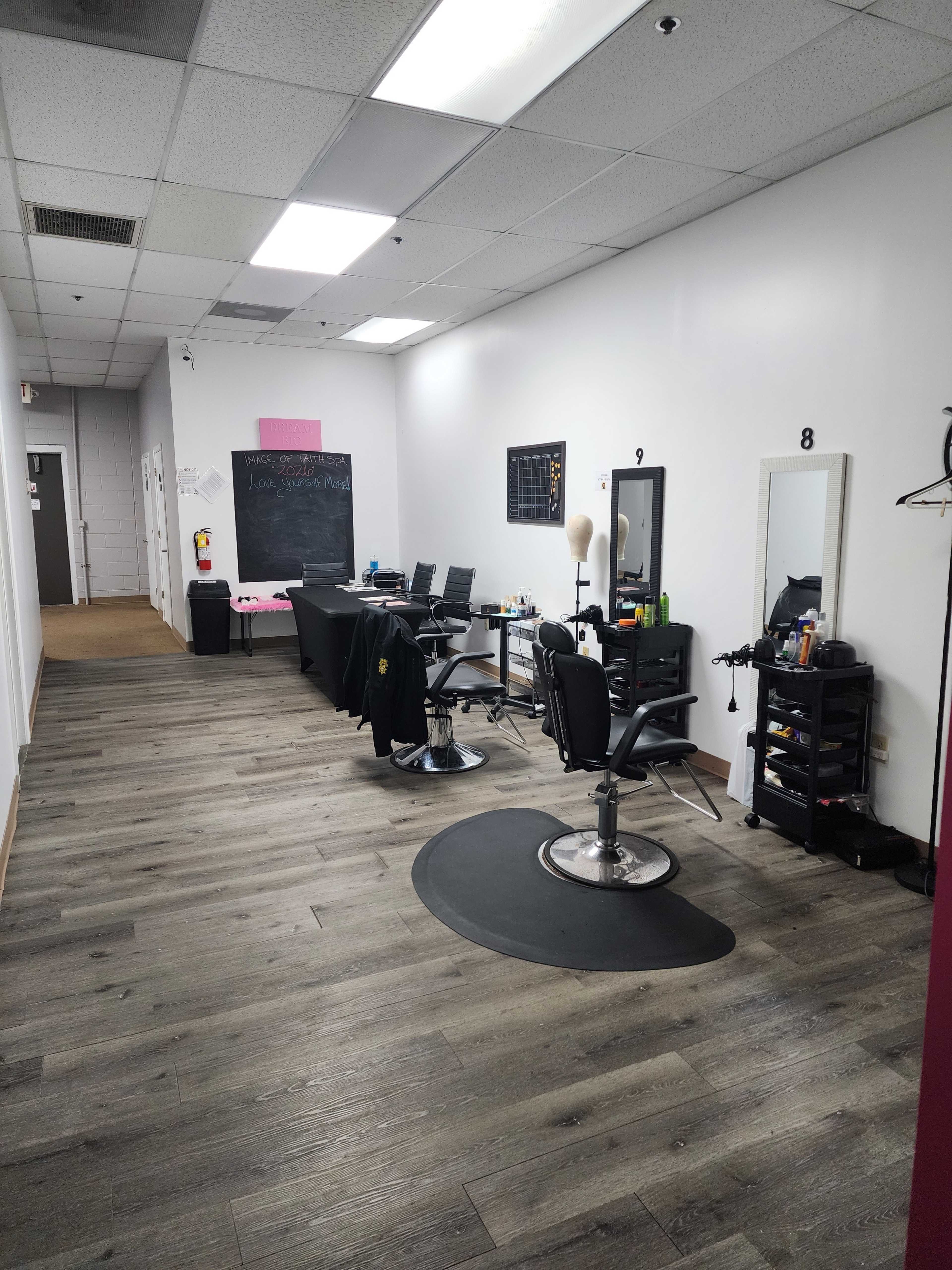 The image shows the interior of a salon with styling chairs, mirrors, and a work station in a brightly lit corridor.