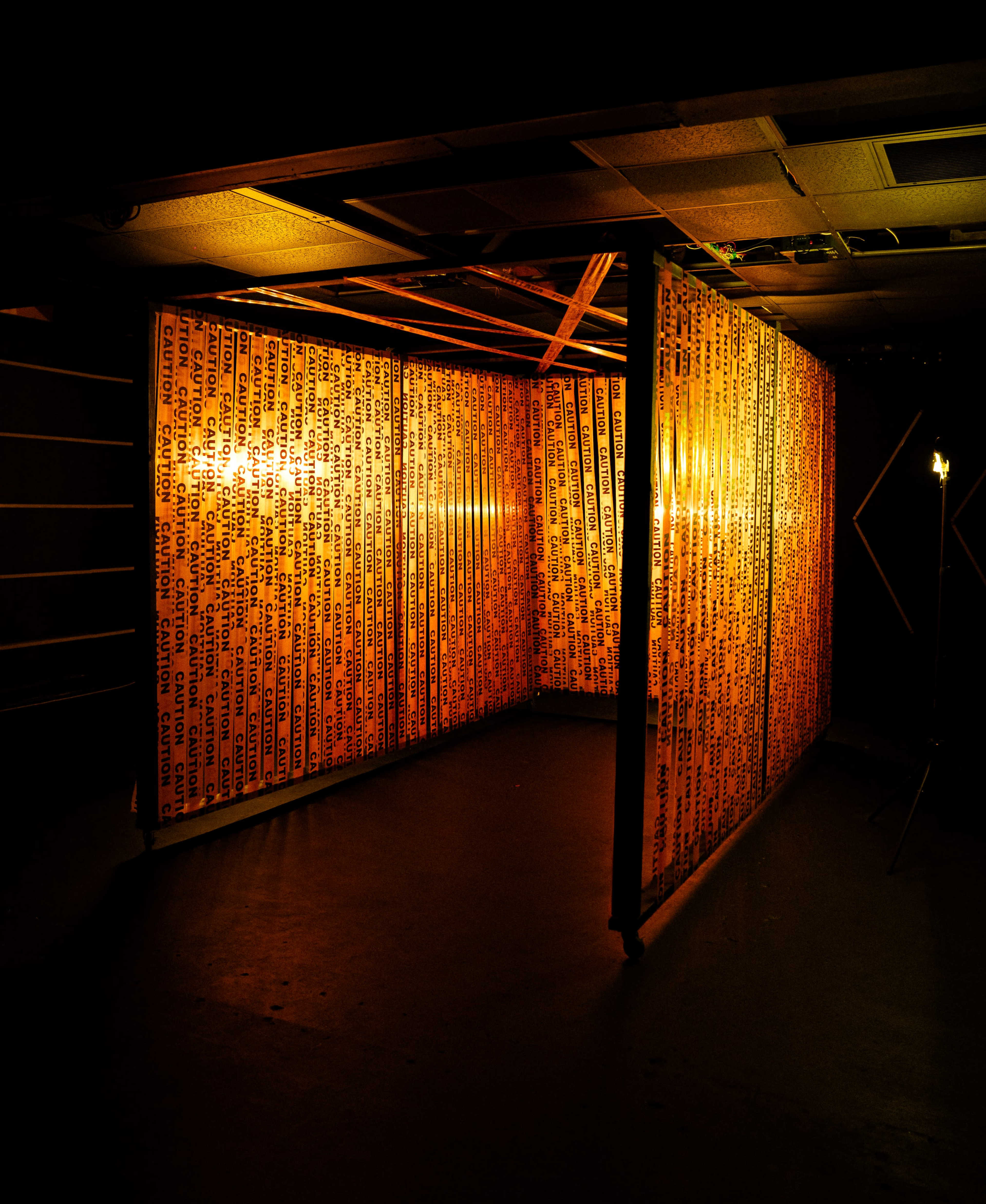 A dimly lit room features walls covered in large, repeated text patterns creating an immersive environment.