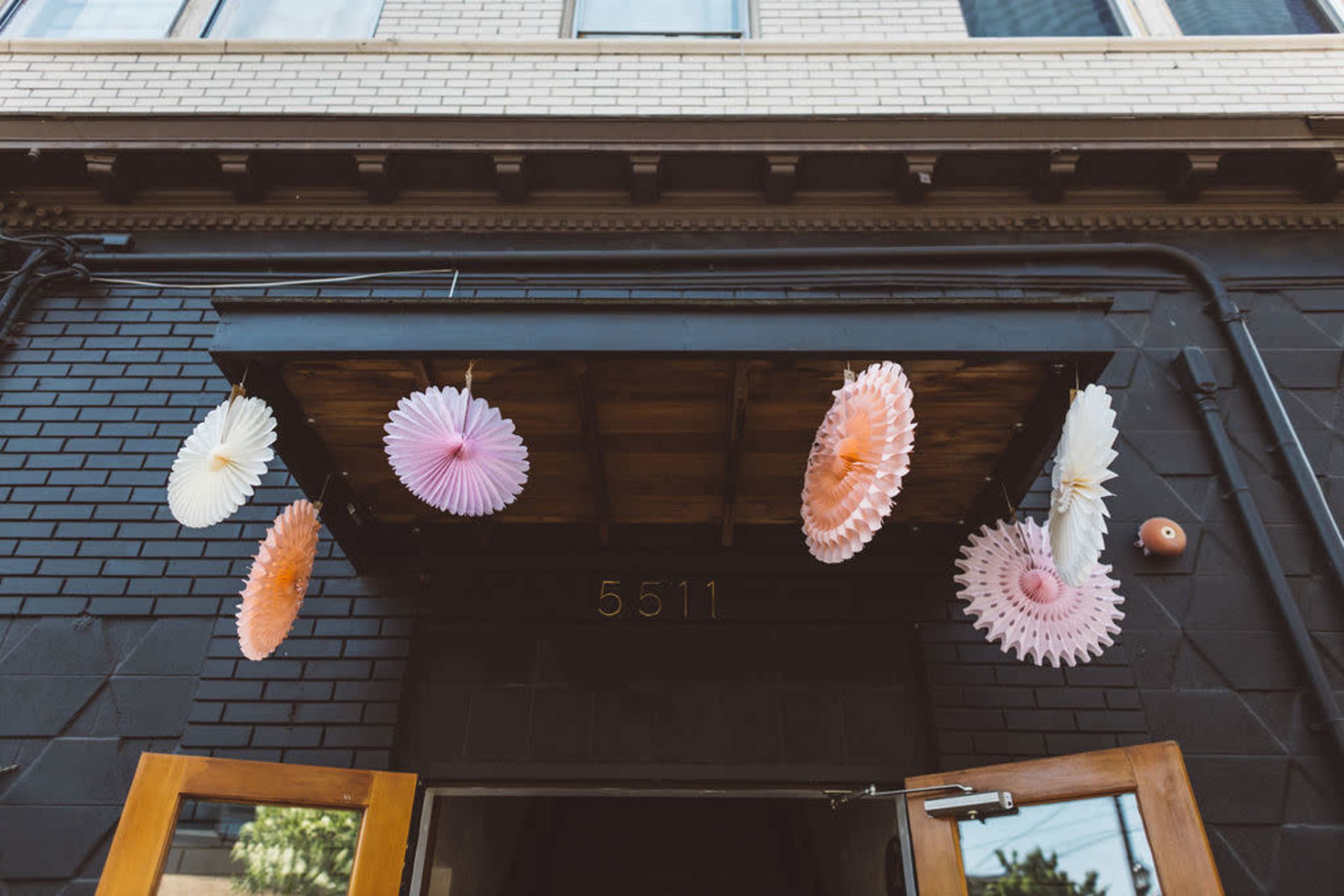 Colorful paper decorations hang above the entrance of a building with the number 5511.