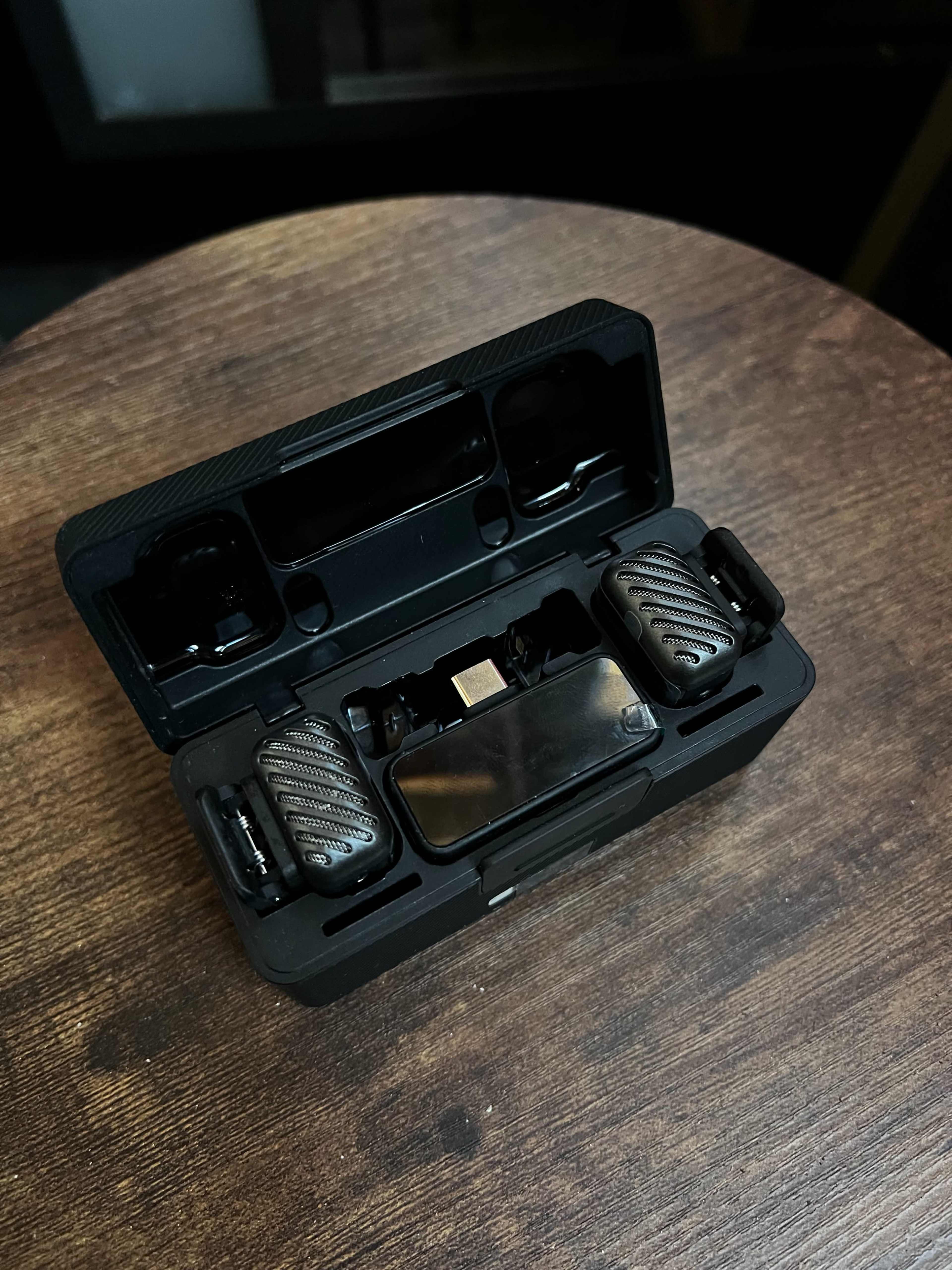The image shows a pair of wireless earbuds inside their charging case placed on a wooden surface.