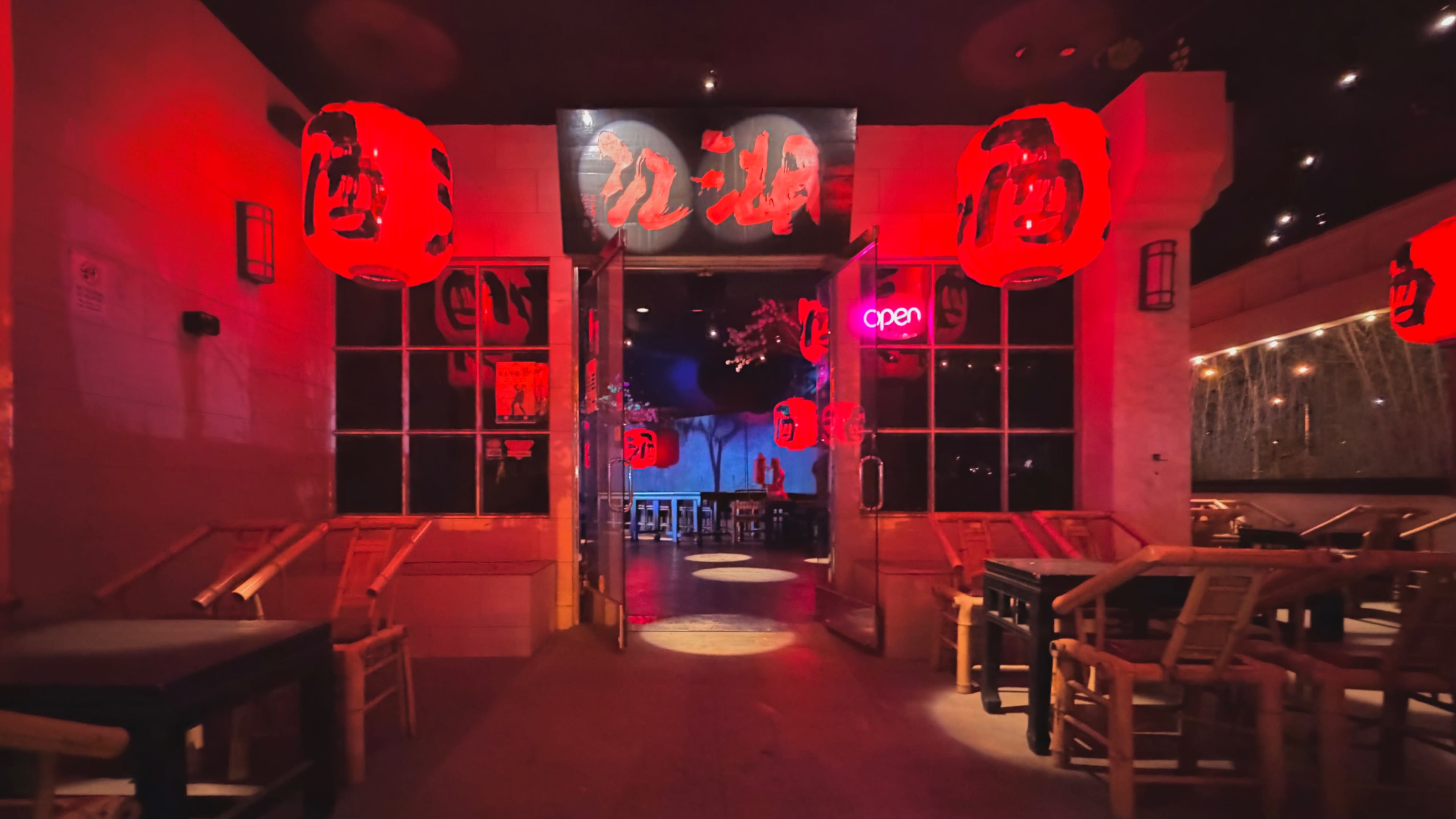 The image shows the entrance of a restaurant with red lanterns and illuminated signs, creating a vibrant atmosphere.